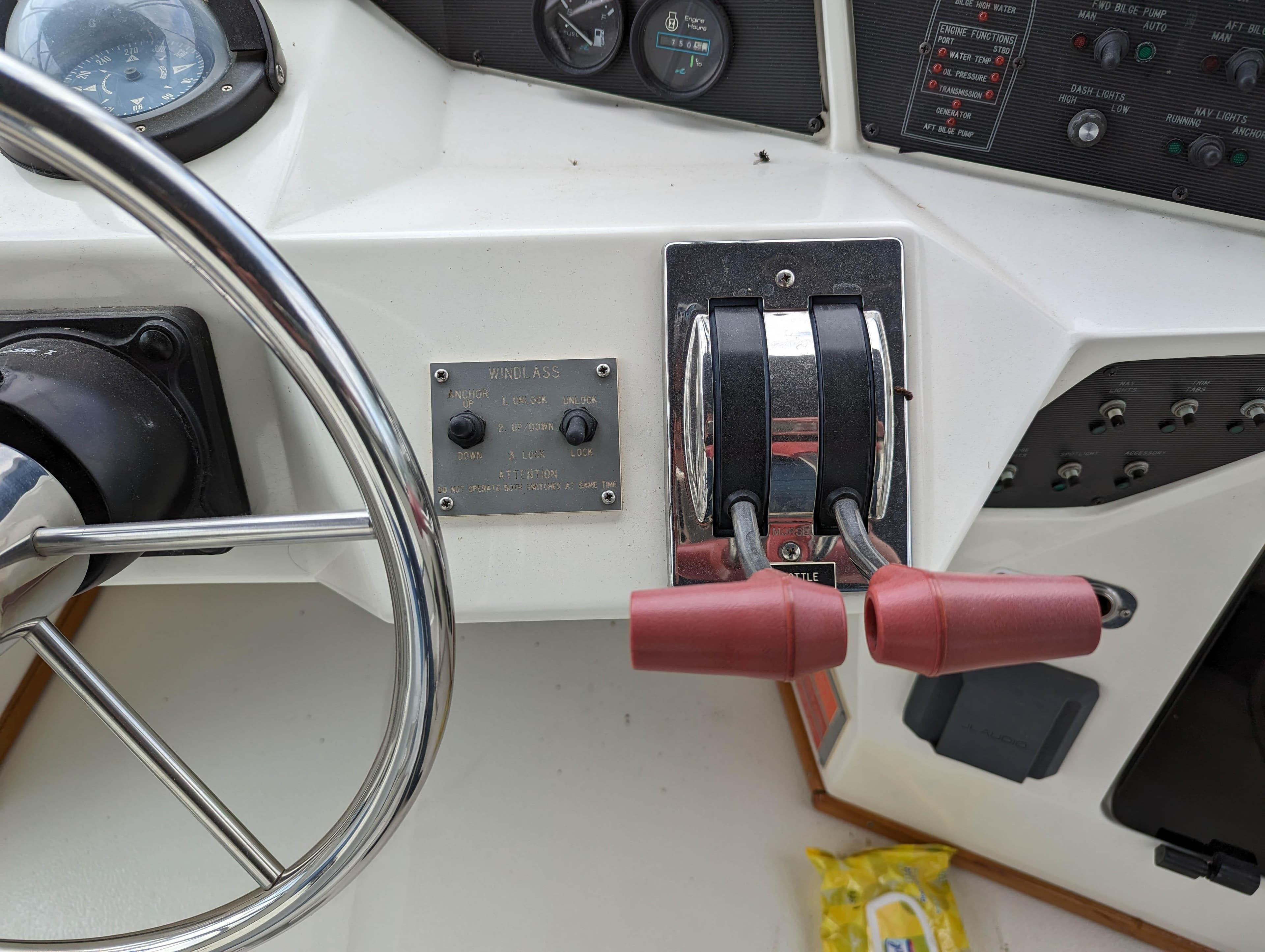 1989 Sea Ray 340 Sedan Bridge helm controls with steering wheel and throttle levers.