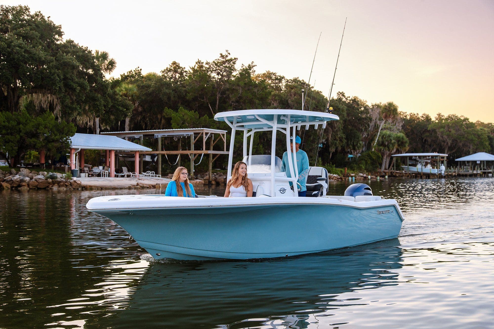 2026 Tidewater 220 LXF boat on calm water at sunset.