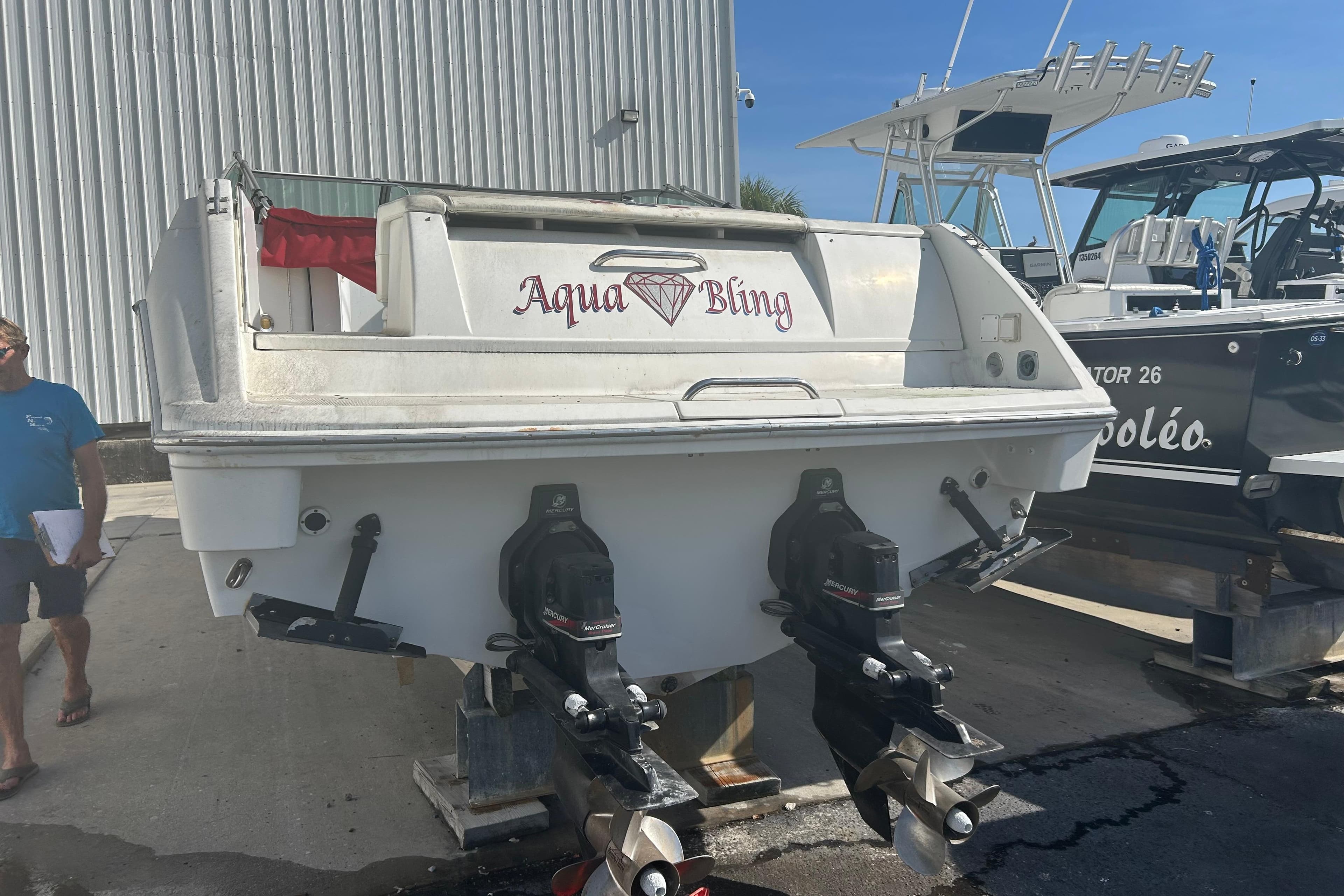 1998 Formula 330 Sun Sport boat named "Aqua Bling" on display at a marina.