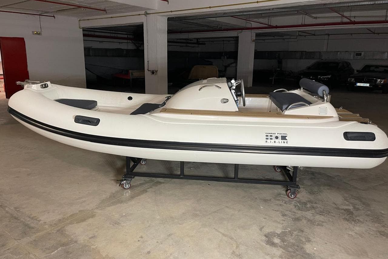 2012 Conrad Pischel inflatable boat in a garage, on a wheeled stand.