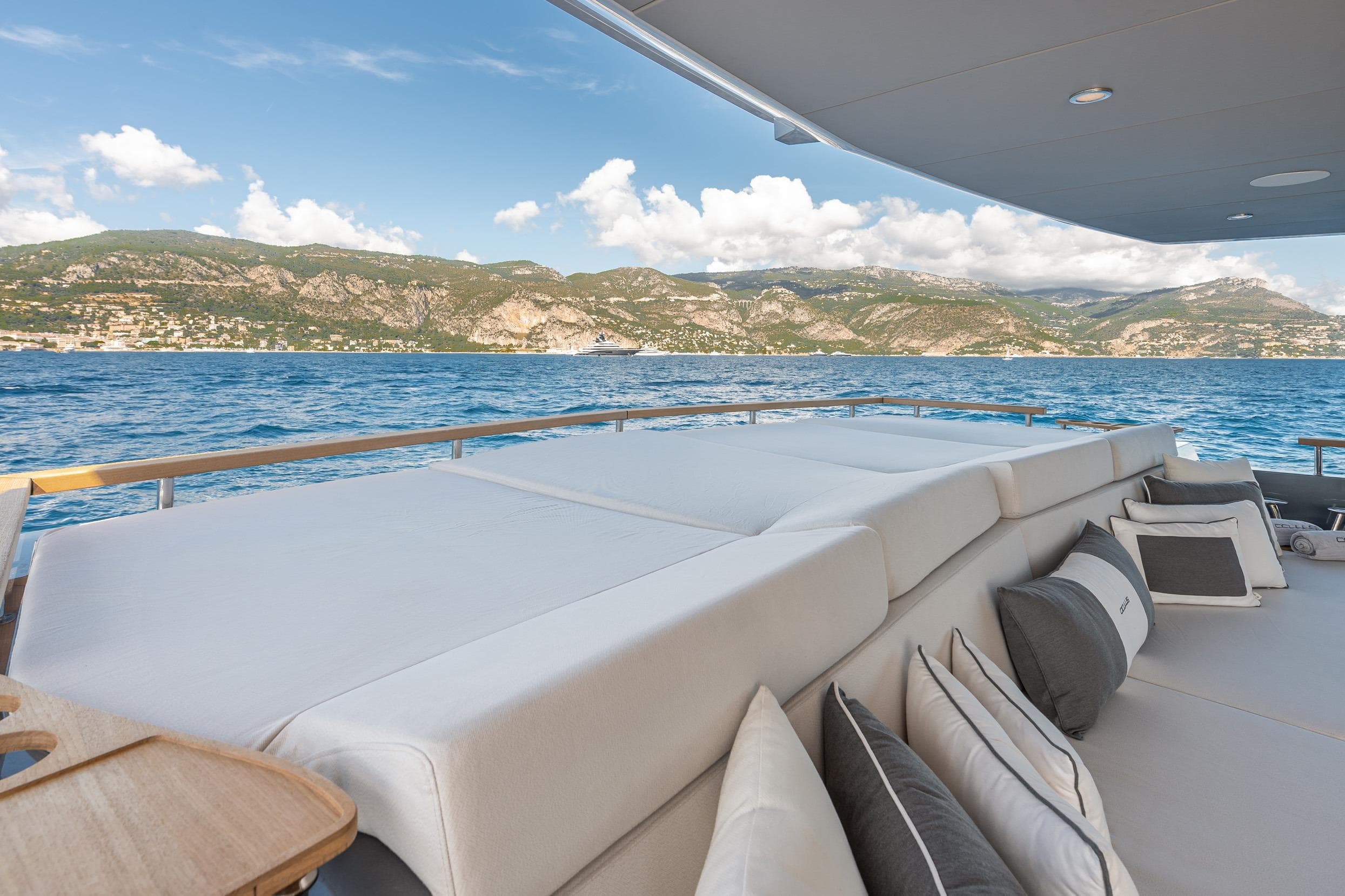 Luxurious 2025 Numarine 37XP yacht deck with scenic ocean and mountain views.