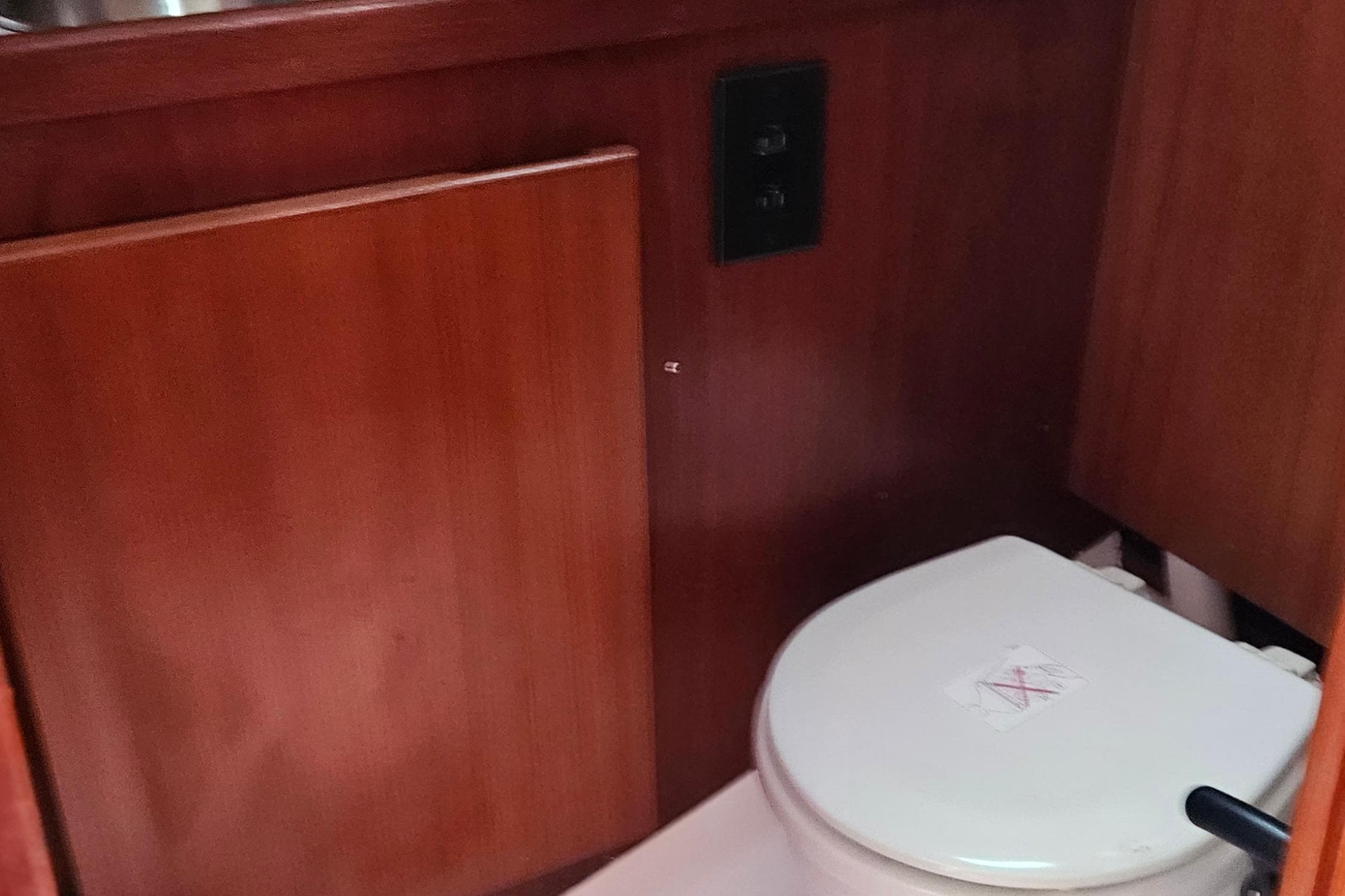 1977 Peterson 34 Sloop interior with wooden paneling and marine toilet.