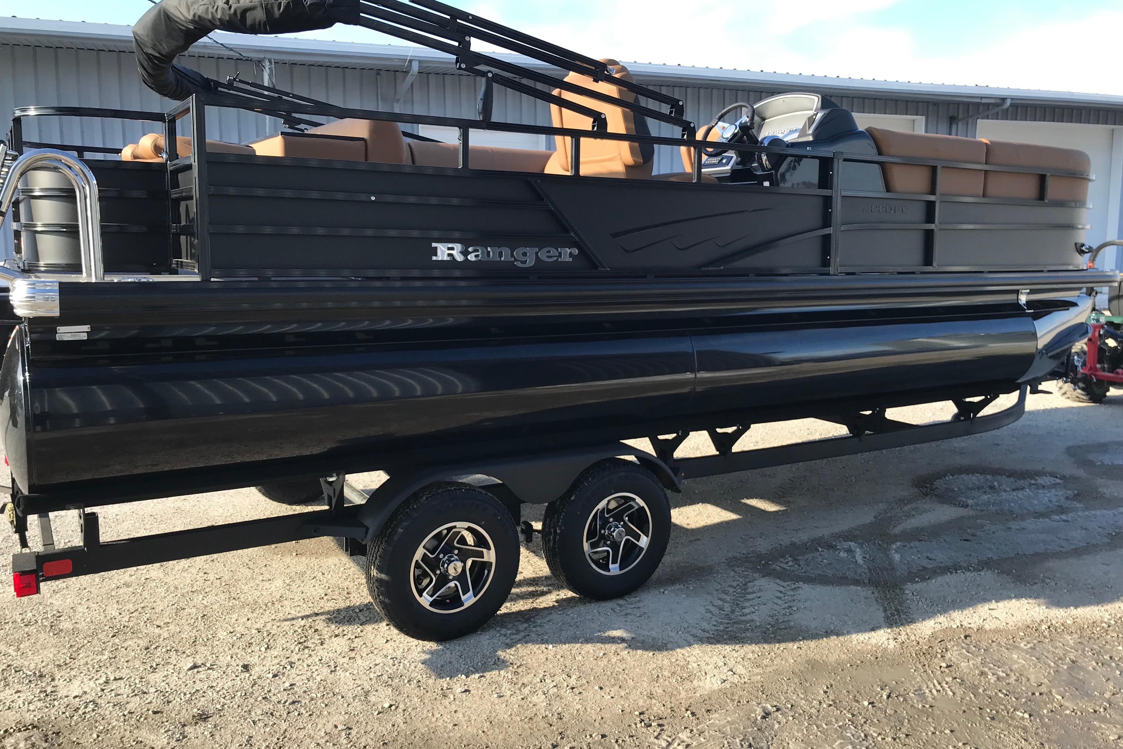 2026 Ranger Reata 220FC pontoon boat on trailer, black exterior, parked outdoors.