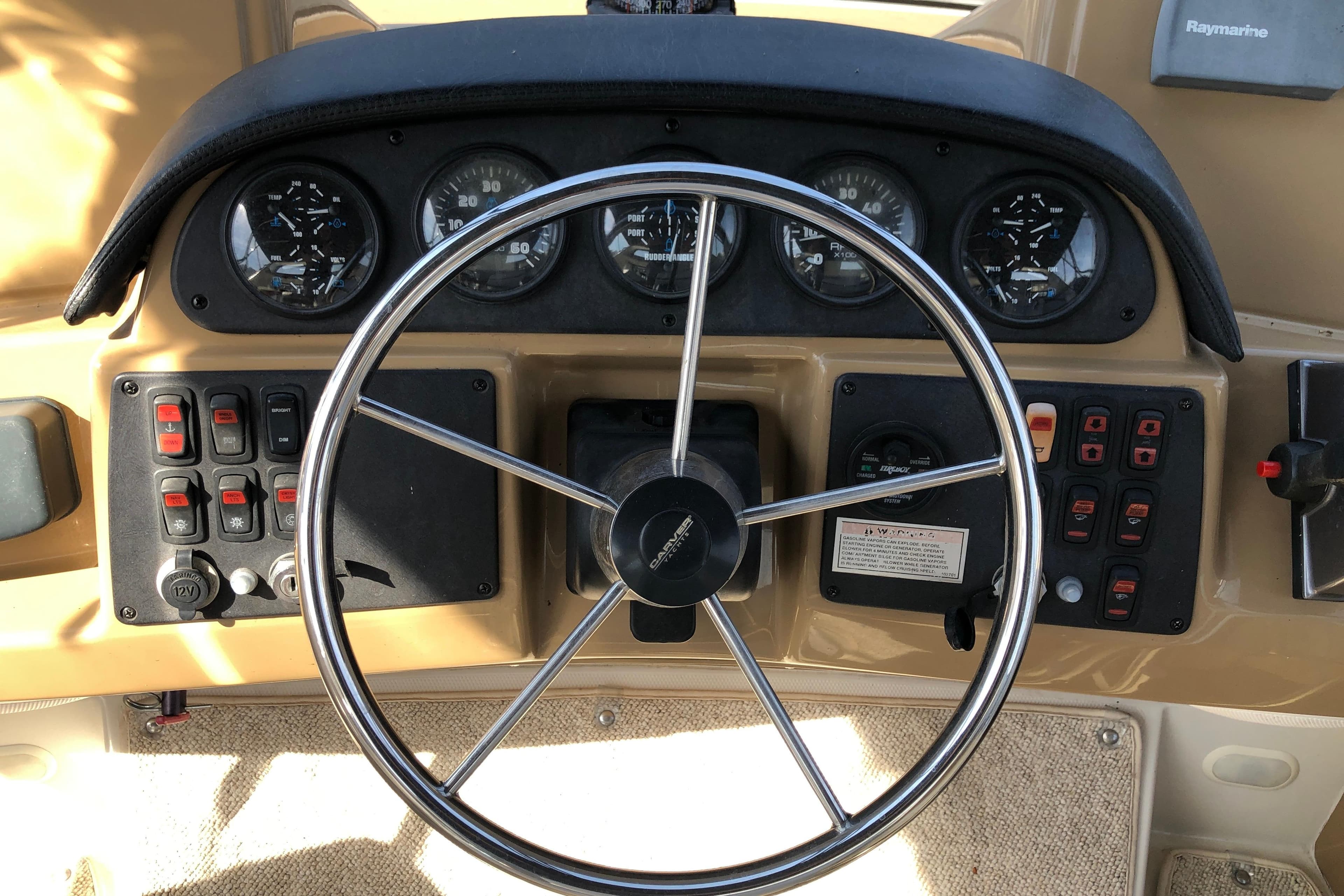 Steering wheel and dashboard of 2004 Carver 366 Motor Yacht with gauges and controls.