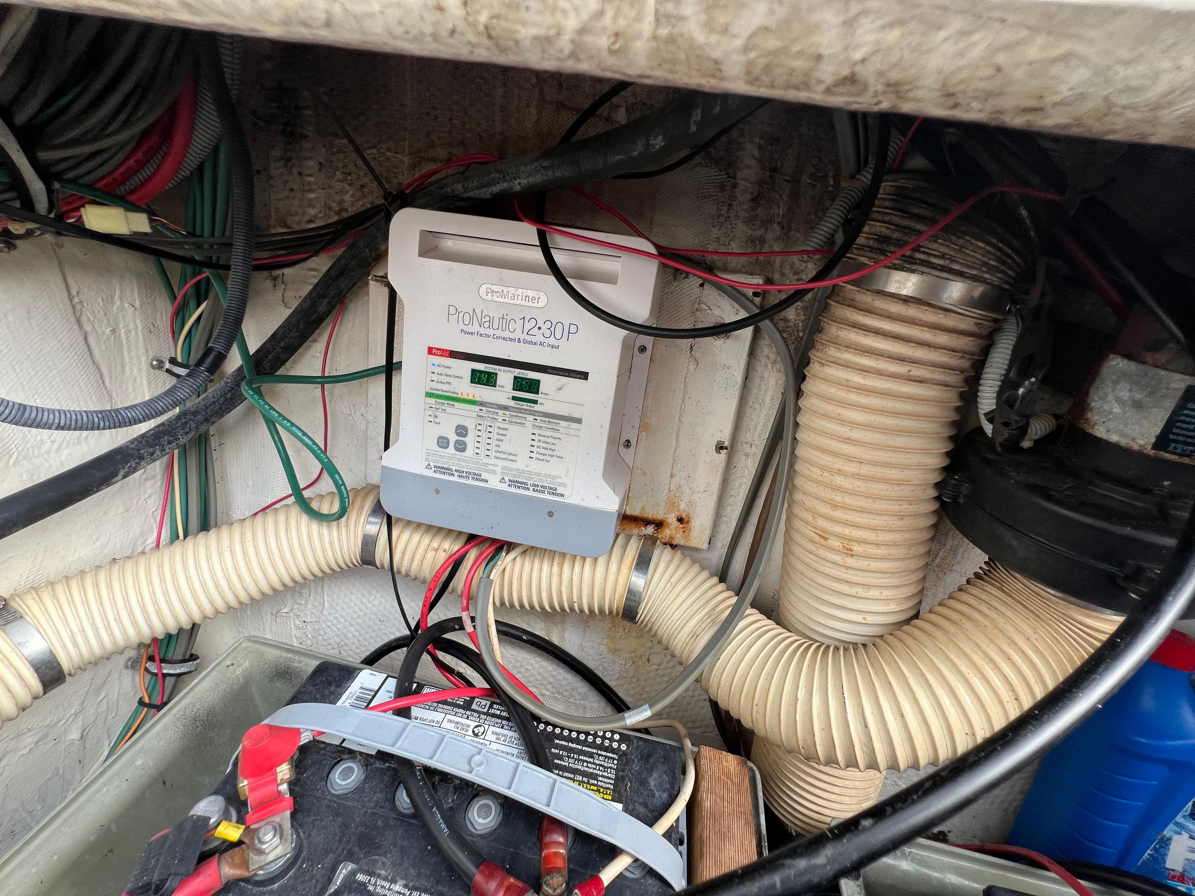 Engine compartment of a 1990 Bertram 28 Flybridge with battery and wiring.