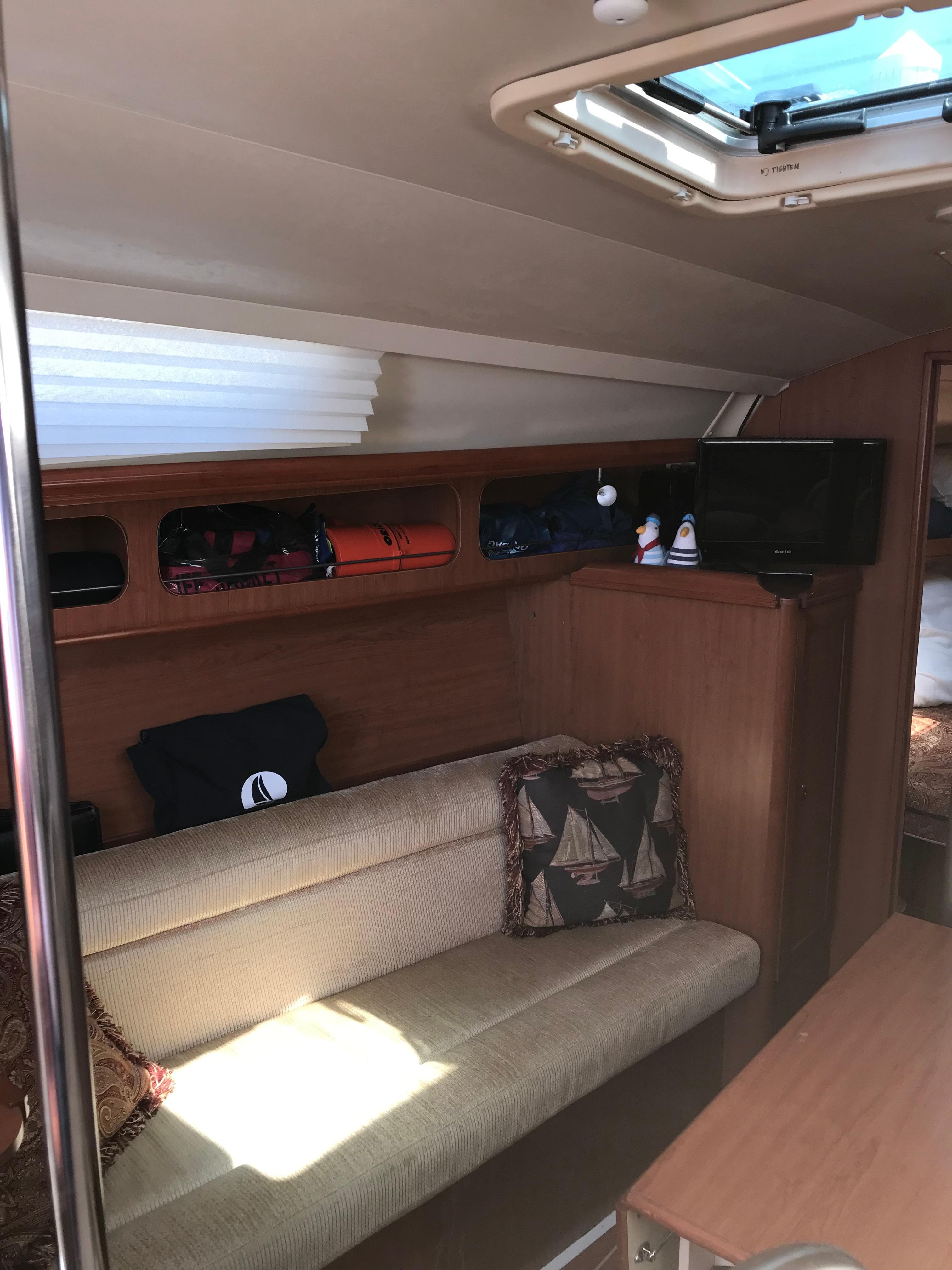 2009 Hunter 310 yacht interior with cozy seating, wooden finish, and natural light.