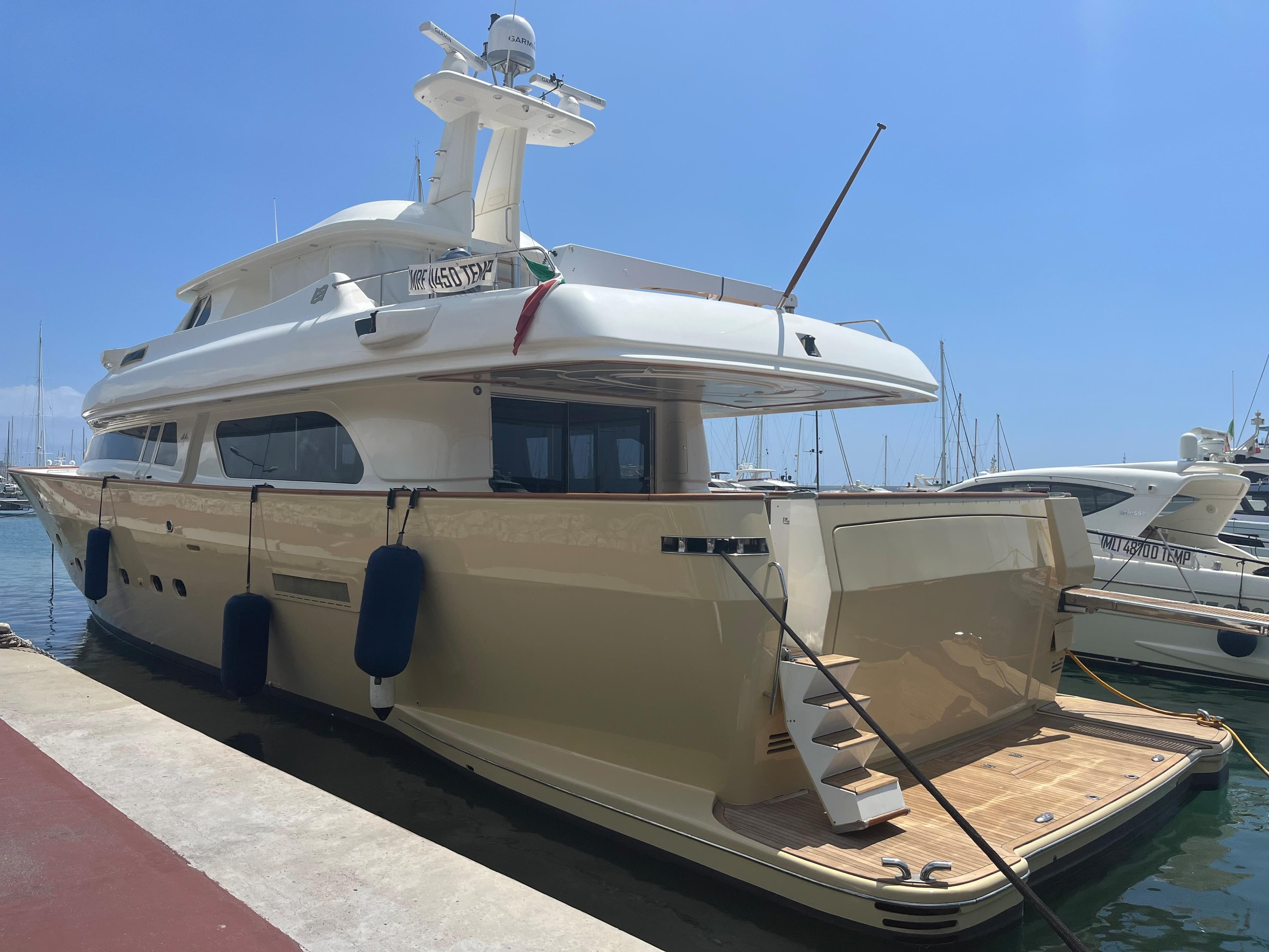 Luxury yacht Custom Line Navetta 27m, 2000 model, docked at marina under clear blue sky.
