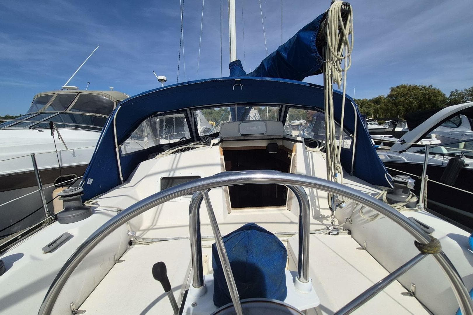 1984 Mirage Yachts 35 sailboat cockpit with blue canopy and steering wheel.