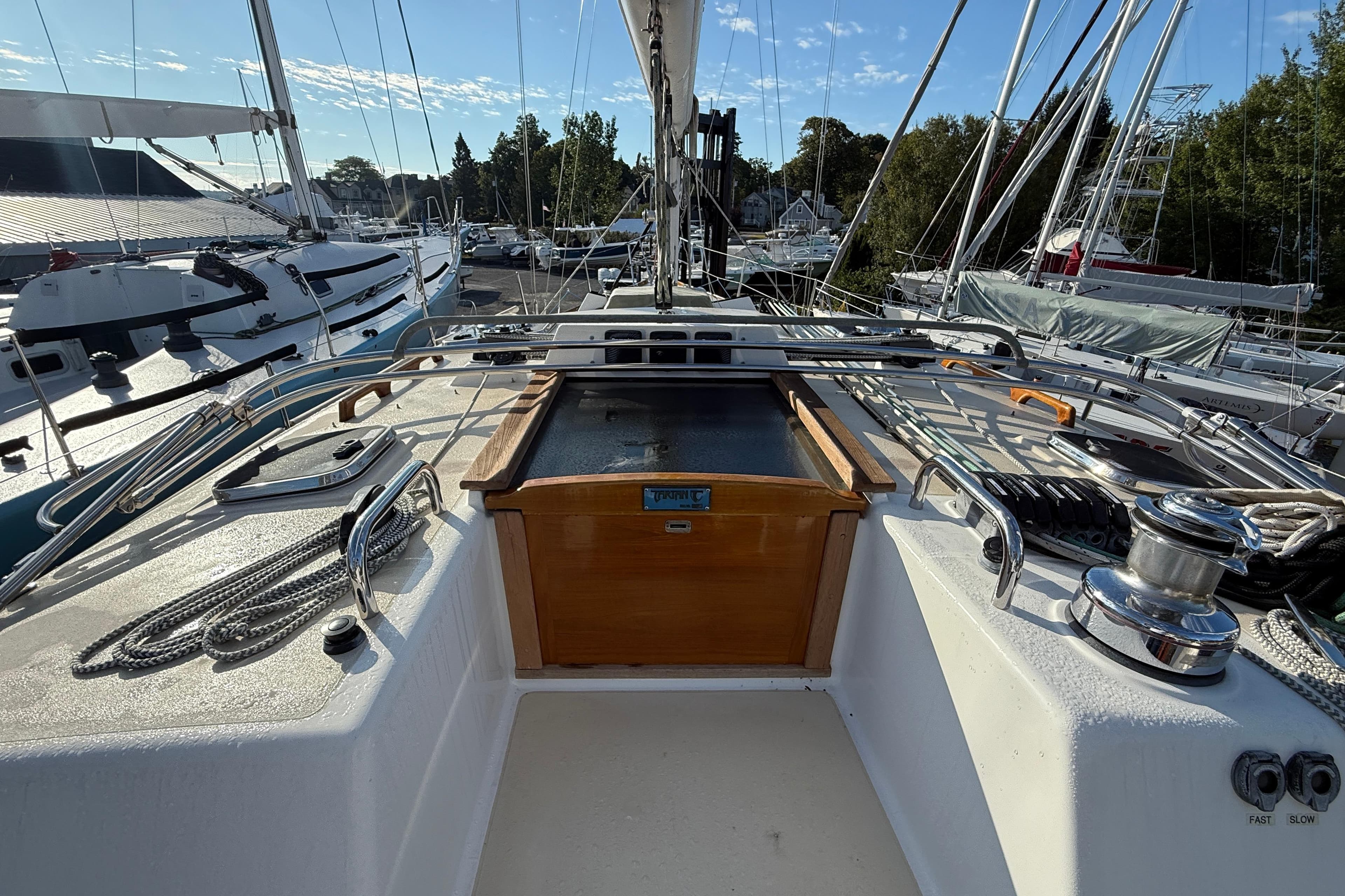 Sailboat deck view of 2011 Tartan 4700, featuring winches and rigging in a marina.