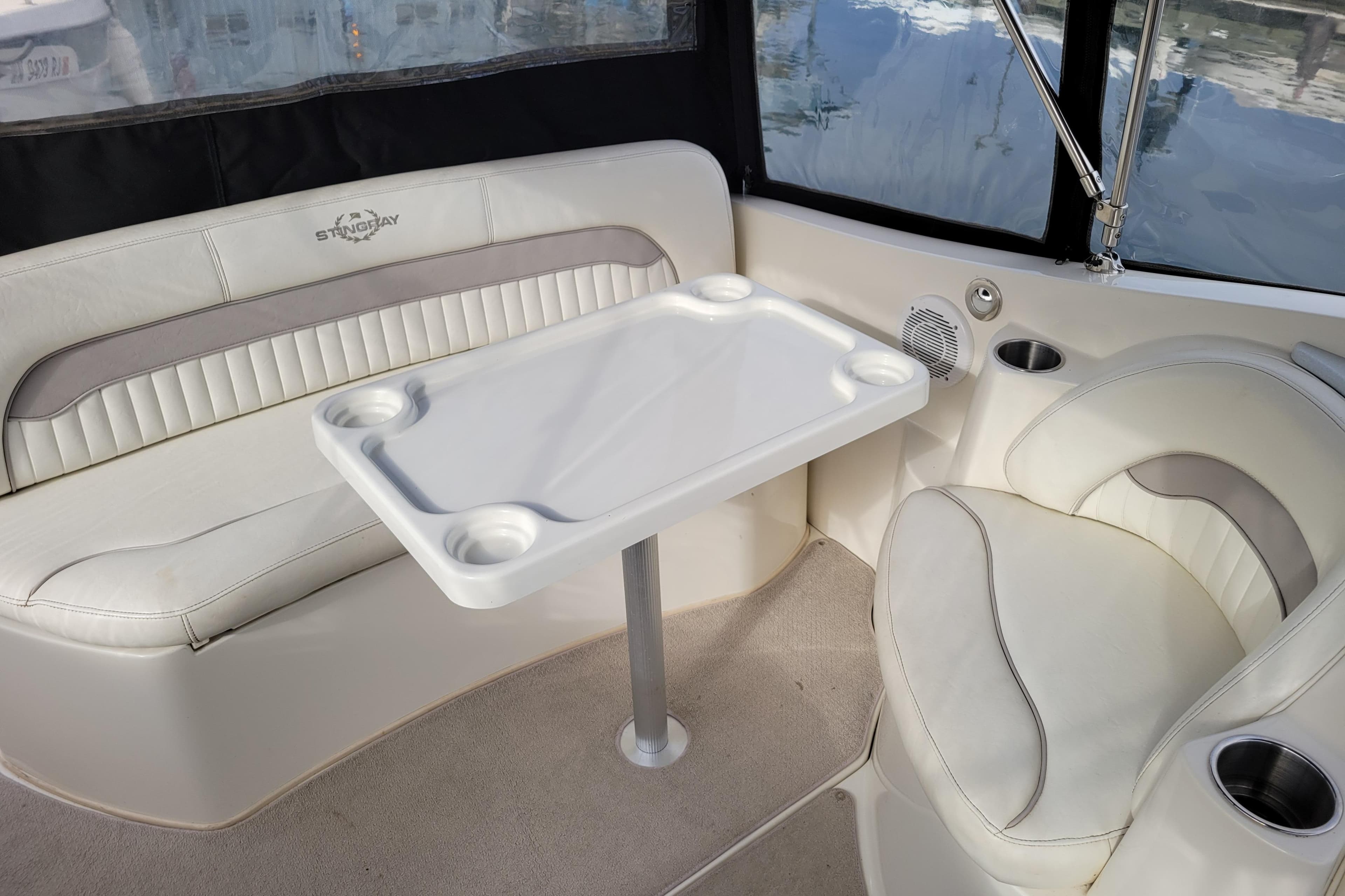 Interior of a 2007 Stingray 250 CS boat with white seating and table.