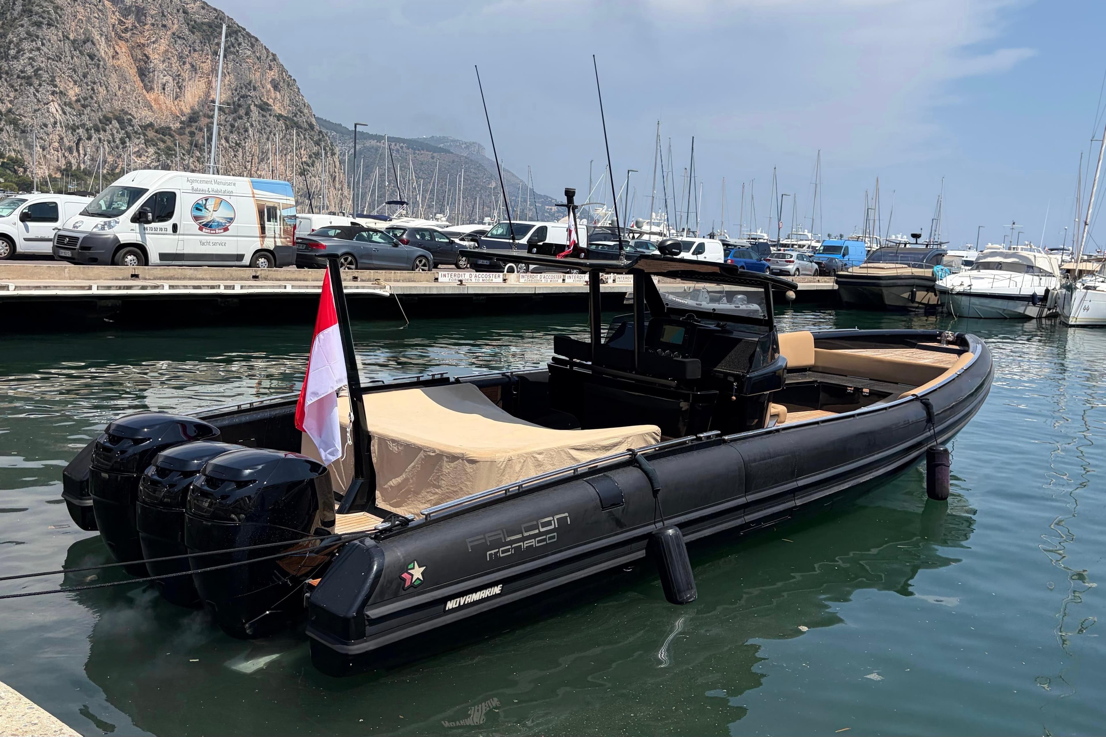 2018 Novamarine BS 120 boat docked in a marina with scenic mountain backdrop.