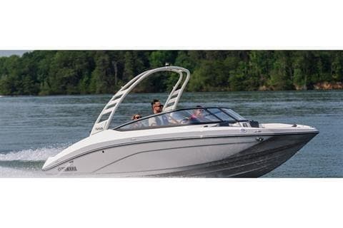 2026 Yamaha Boats 195S cruising on a lake with lush green trees in the background.
