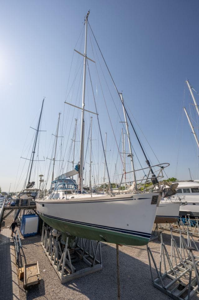 Hylas 54 Raised Saloon 2001 sailboat on dry dock under clear blue sky.