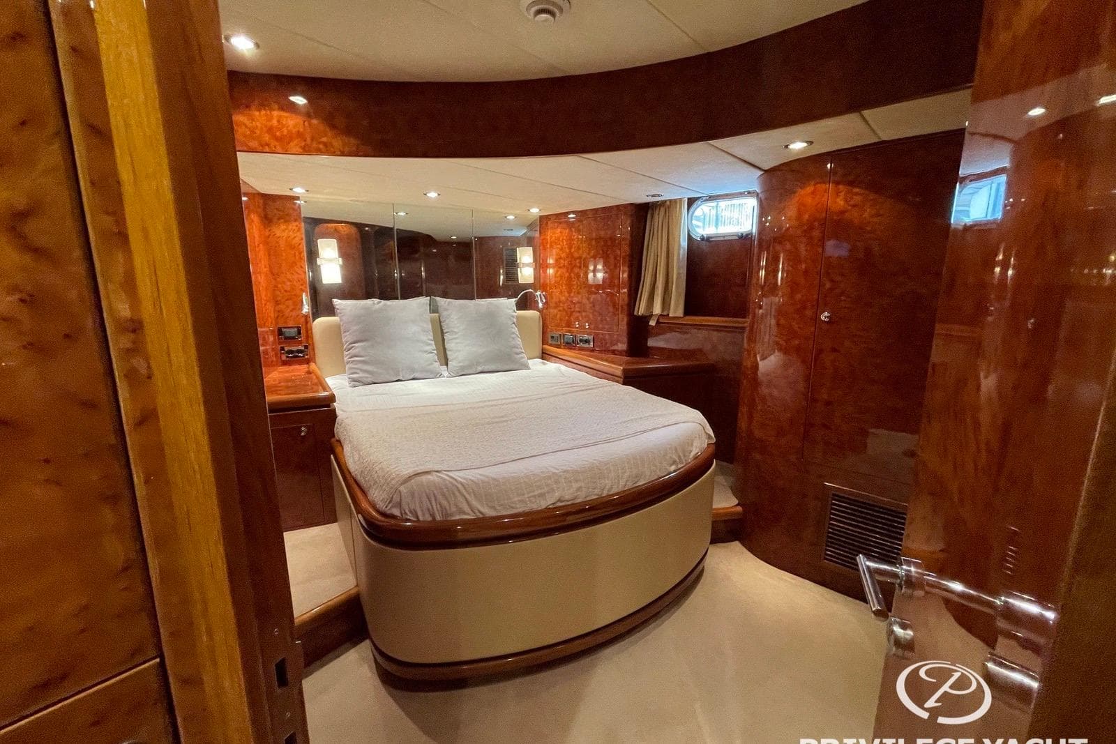 Luxurious bedroom interior of 2006 Monte Fino 76 yacht with elegant wood finishes.