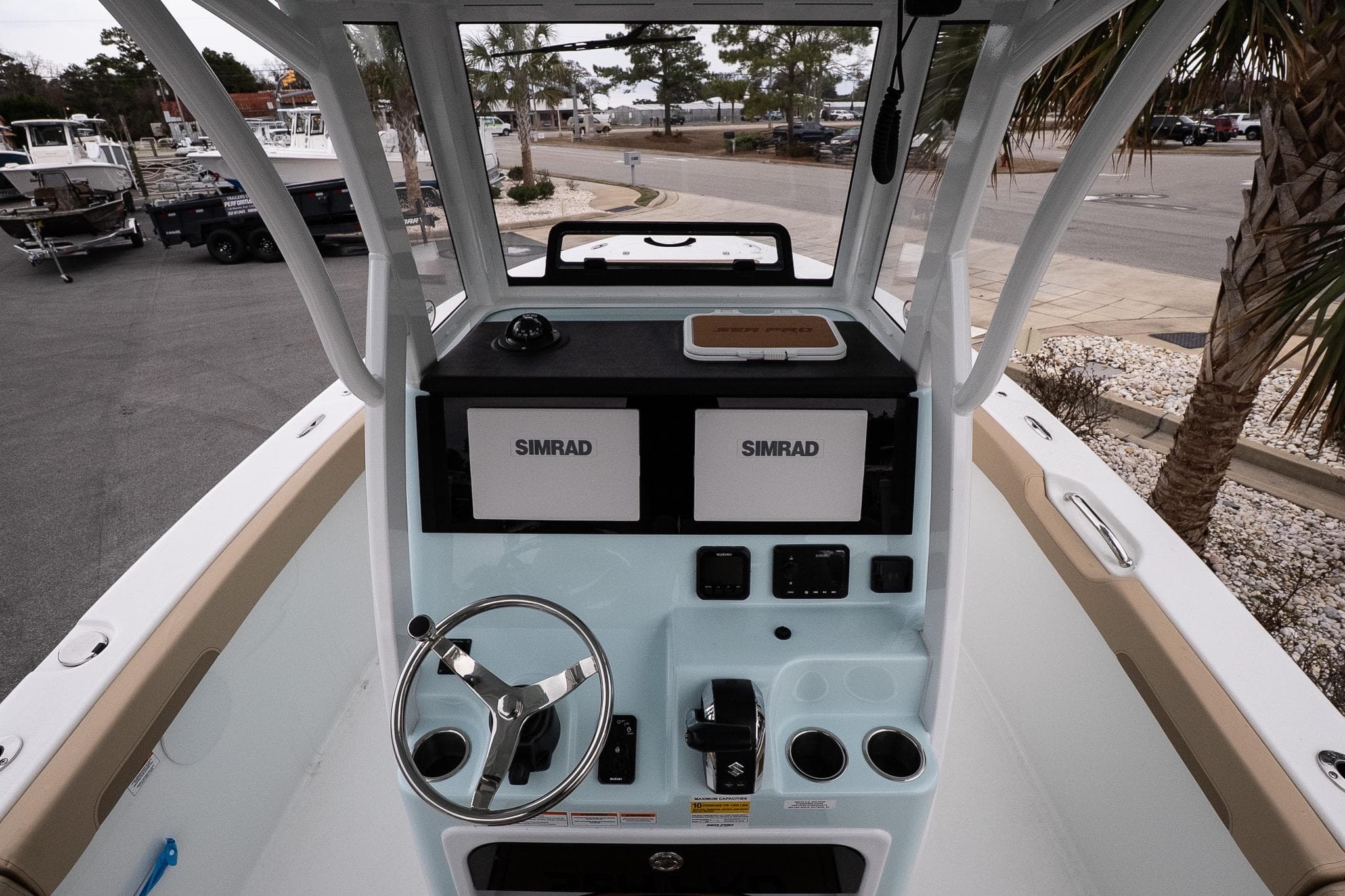 2026 Sea Pro 245FLXR Sandbar boat console with Simrad displays and steering wheel.