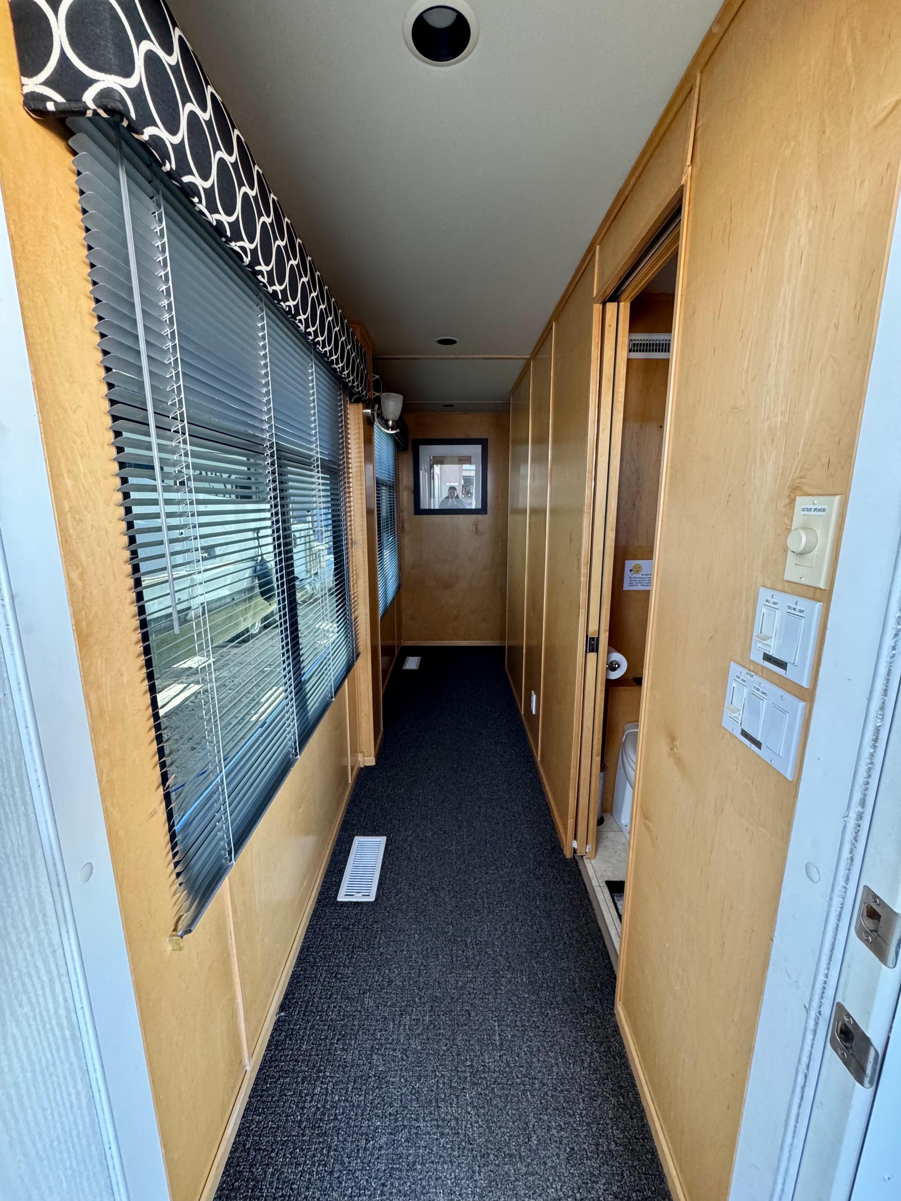 Narrow hallway in 2006 Sumerset Seas The Day Trip 11 houseboat with wood paneling and window blinds.