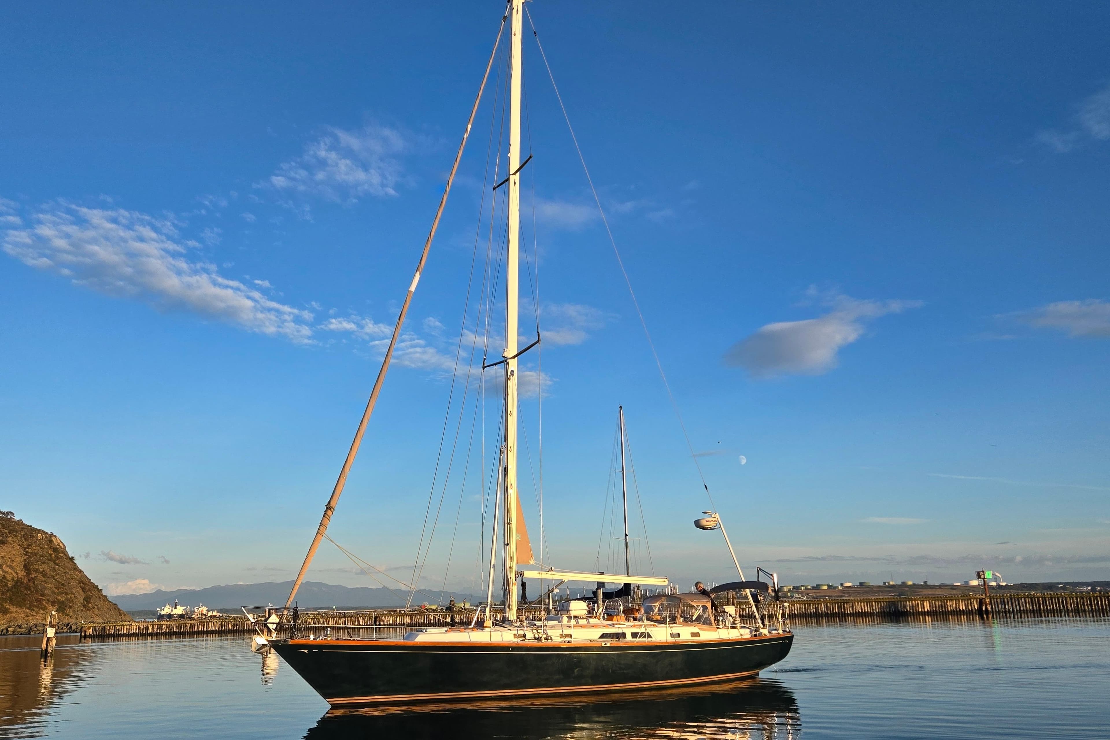 Sailboat Cambria 46, 1986 model, on calm water under a clear blue sky.