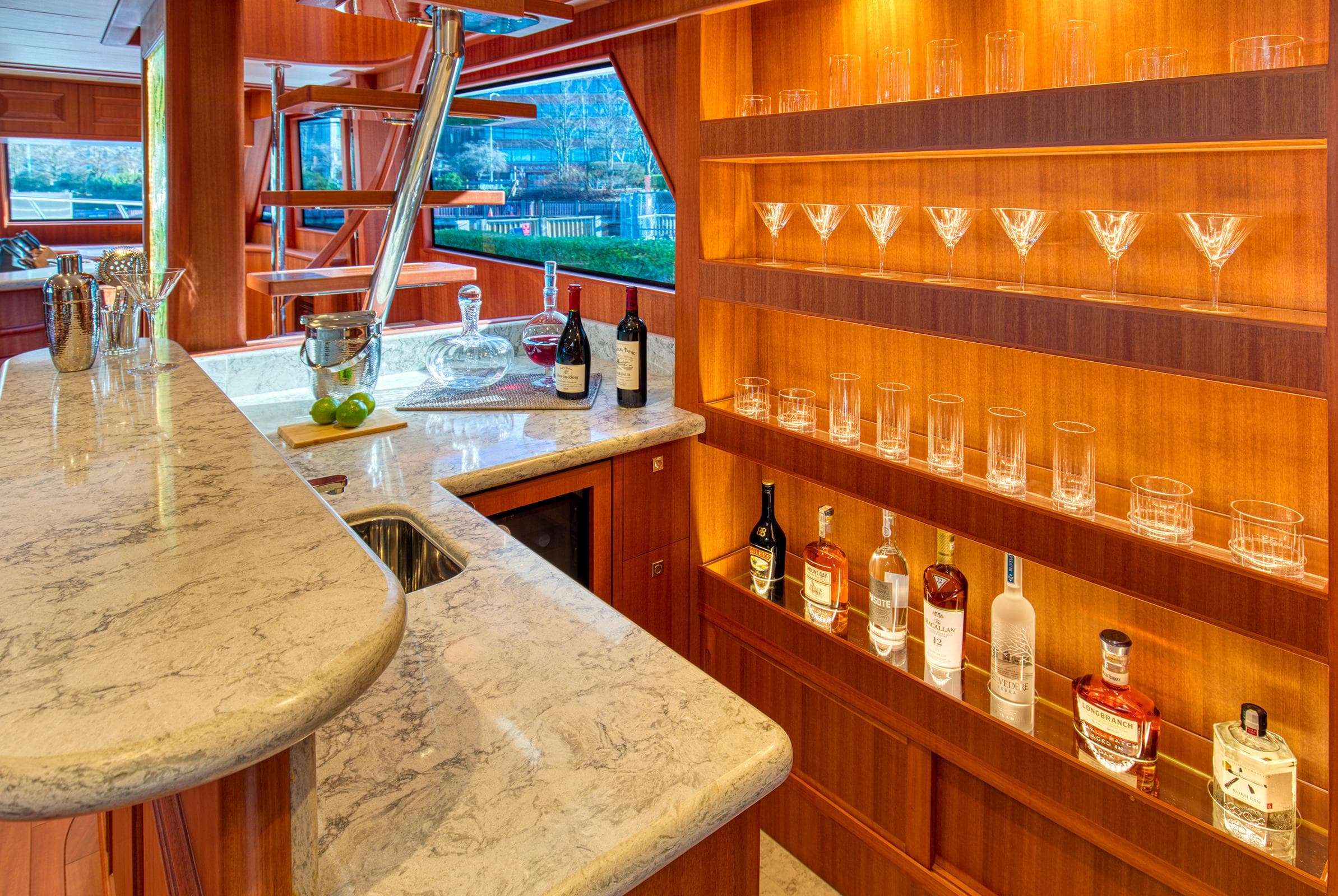 Luxurious bar area on 2025 Hampton 750 Endurance LRC yacht with marble countertop and glassware display.