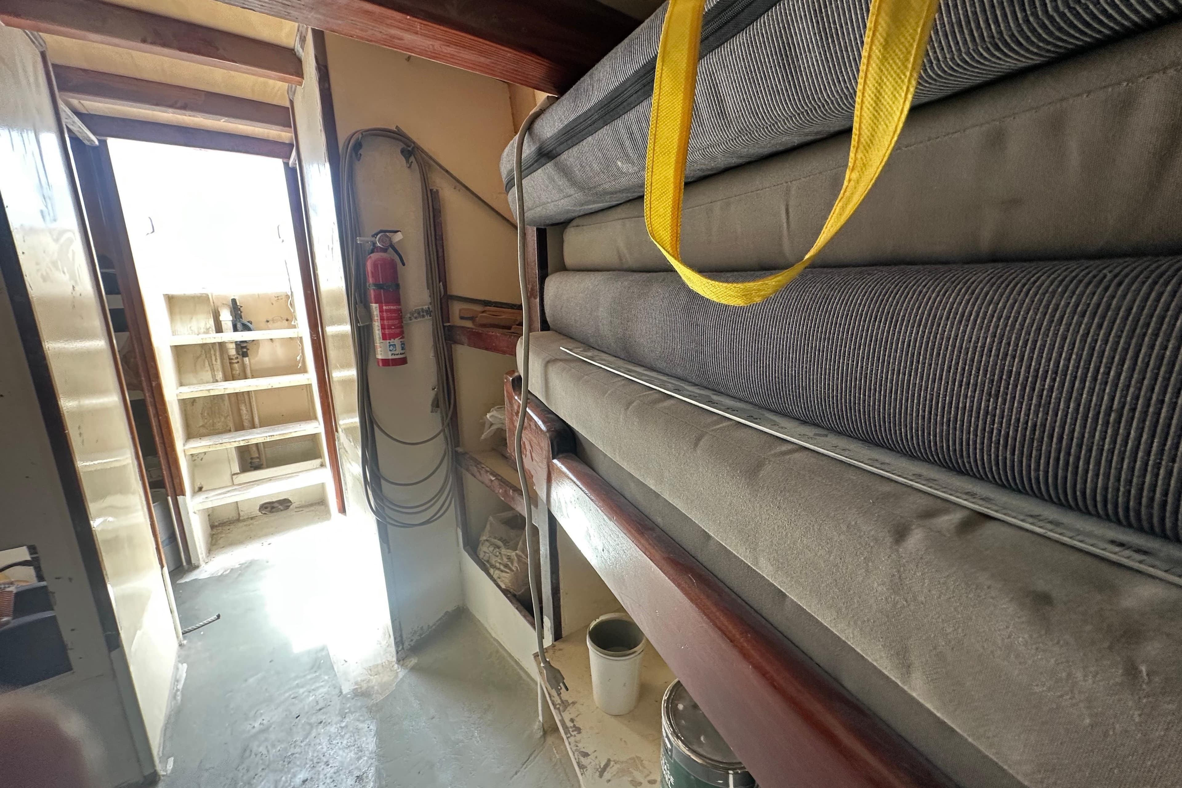 Interior of 1994 Pilot Schooner Leopard with stacked cushions and fire extinguisher.
