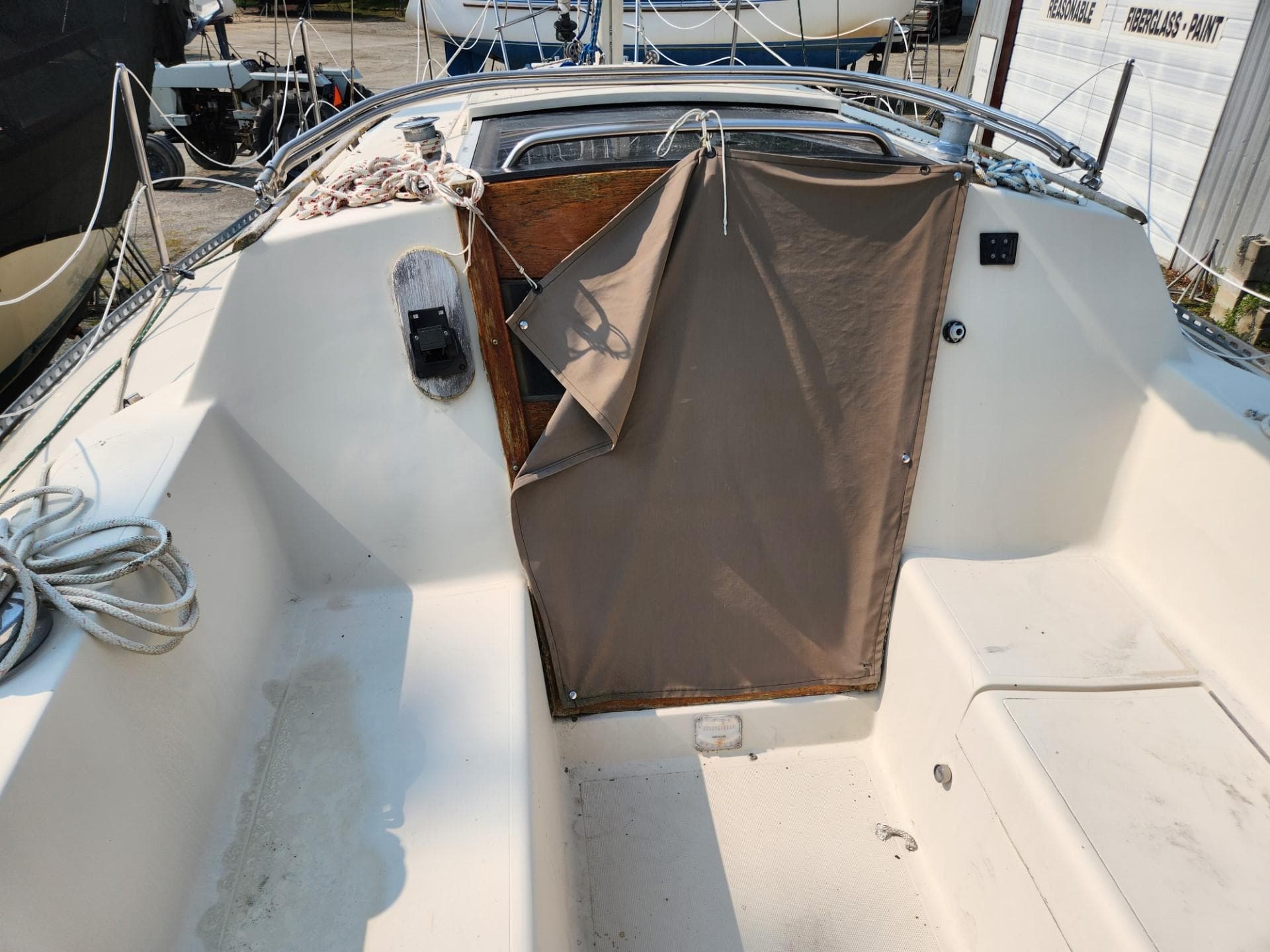 1984 S2 9.2 sailboat cockpit with covered companionway and coiled rope.