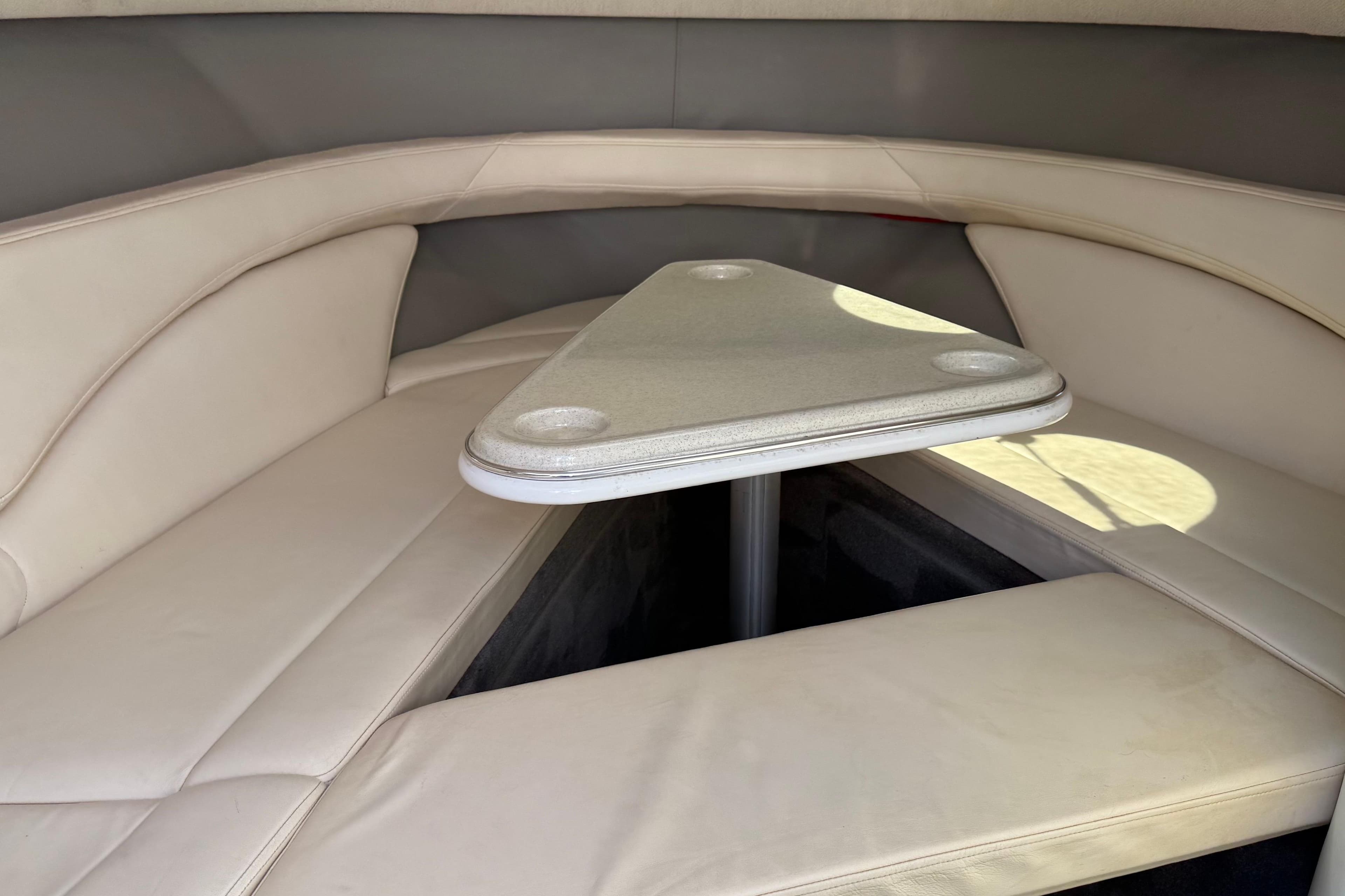 1999 Cobalt 293 boat interior with beige seating and triangular table.