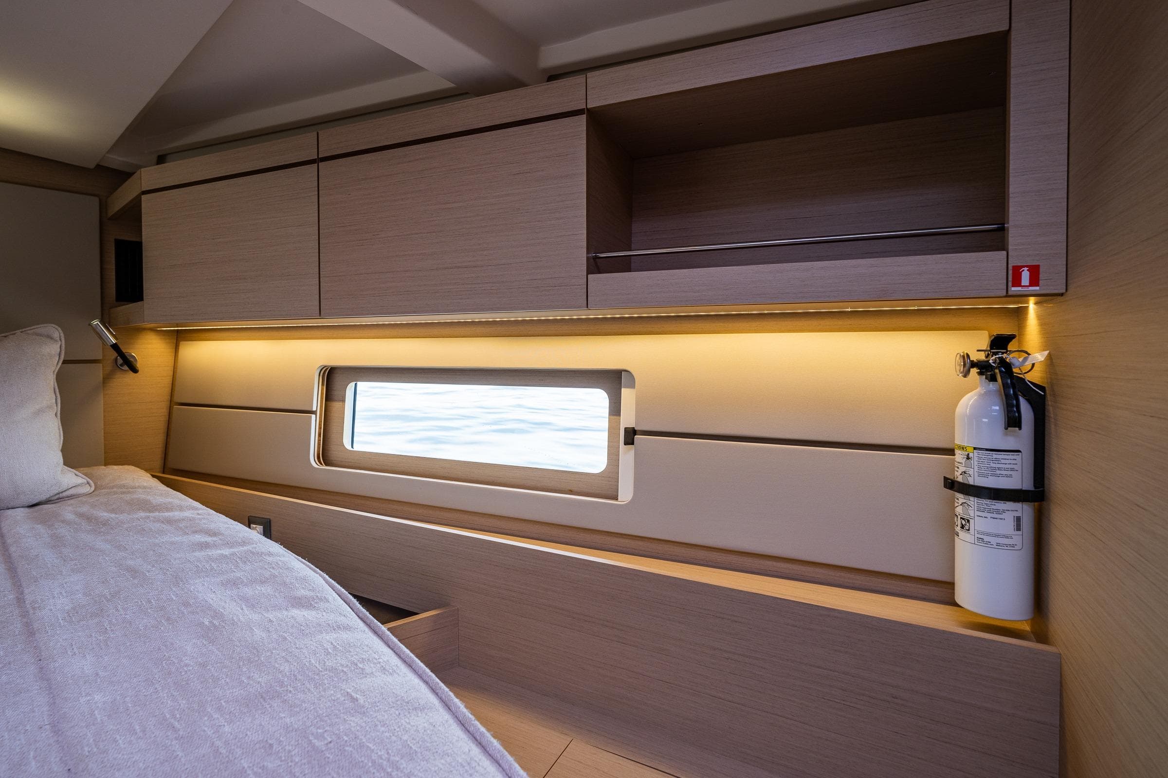 Interior cabin of 2020 Beneteau Oceanis 46.1 yacht with window and fire extinguisher.