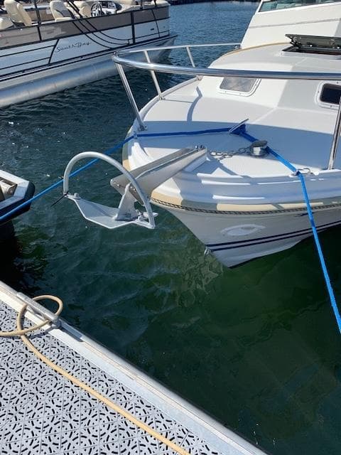 1989 Limestone 24 Express Cruiser docked with anchor and blue ropes.