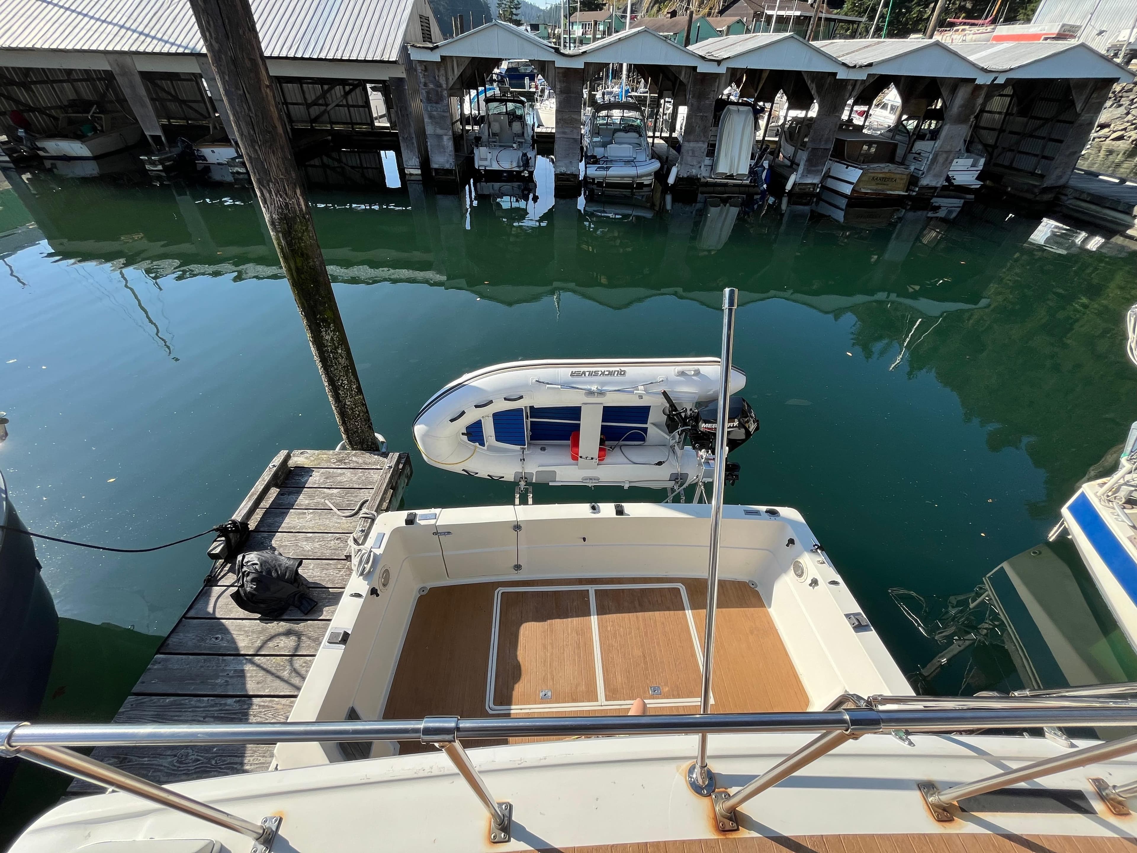 1976 Fiberform Executive 3300 boat docked at marina with small dinghy nearby.
