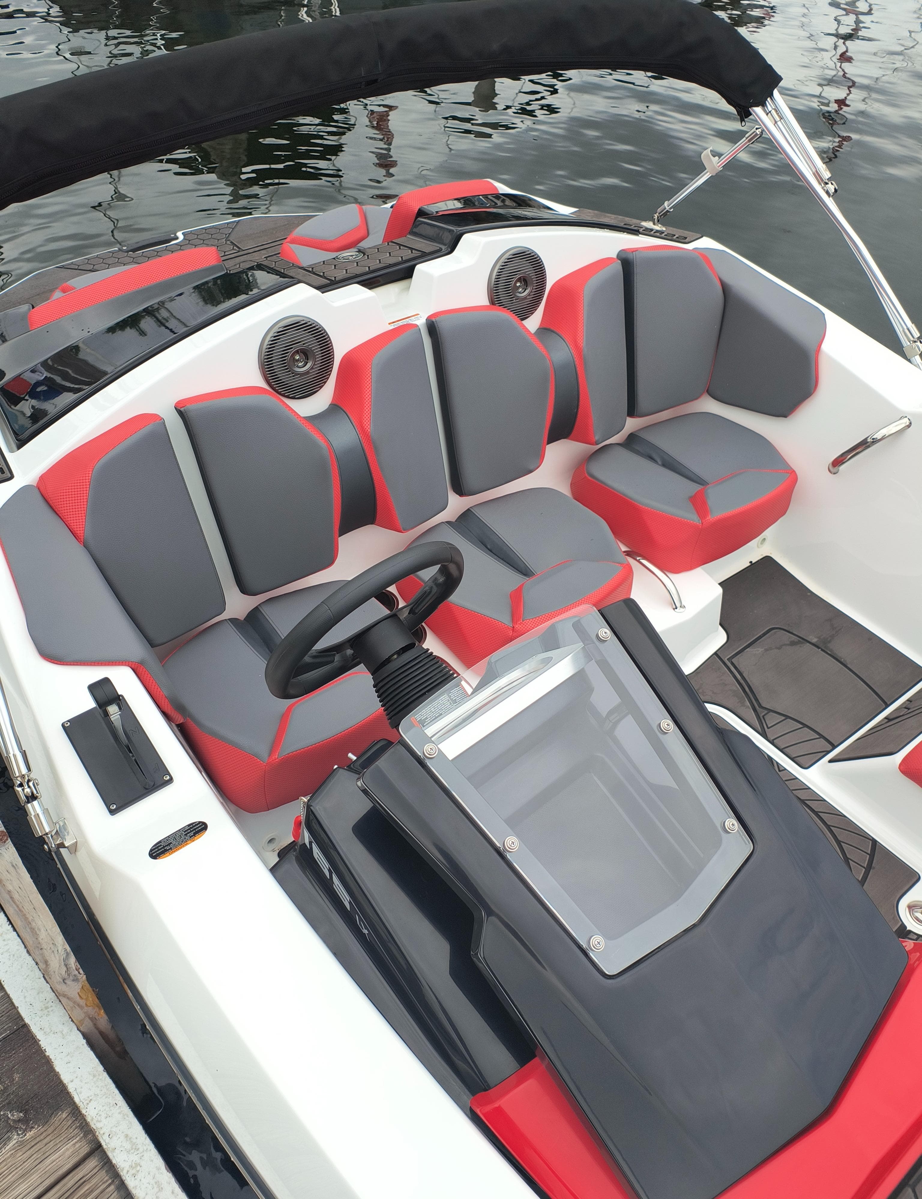 2025 Scarab 165 LX boat interior with red and gray seating, steering wheel, and dashboard.