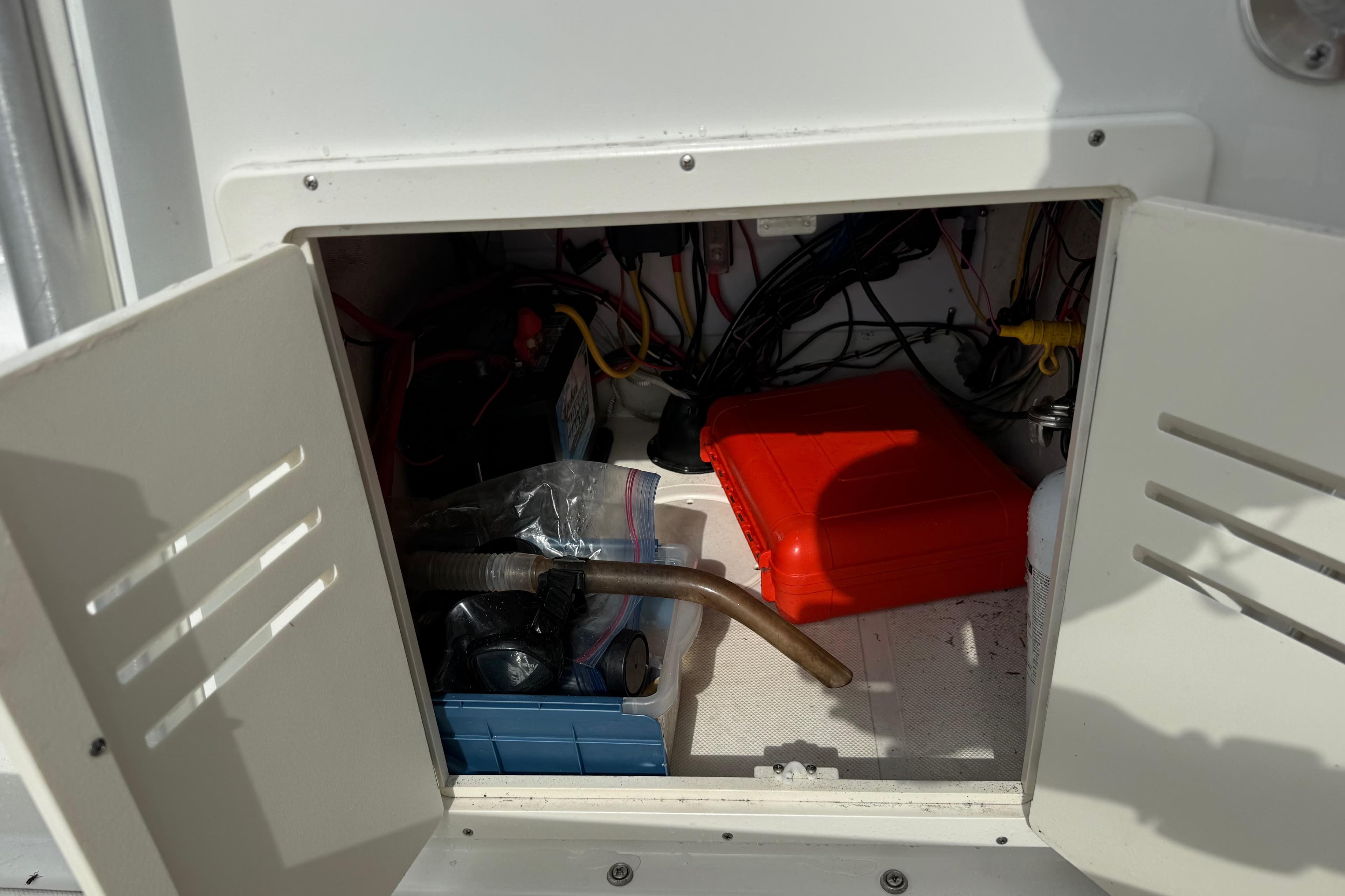 Open storage compartment on 2016 Panga 22 BOCA GRANDE boat with tools and equipment.