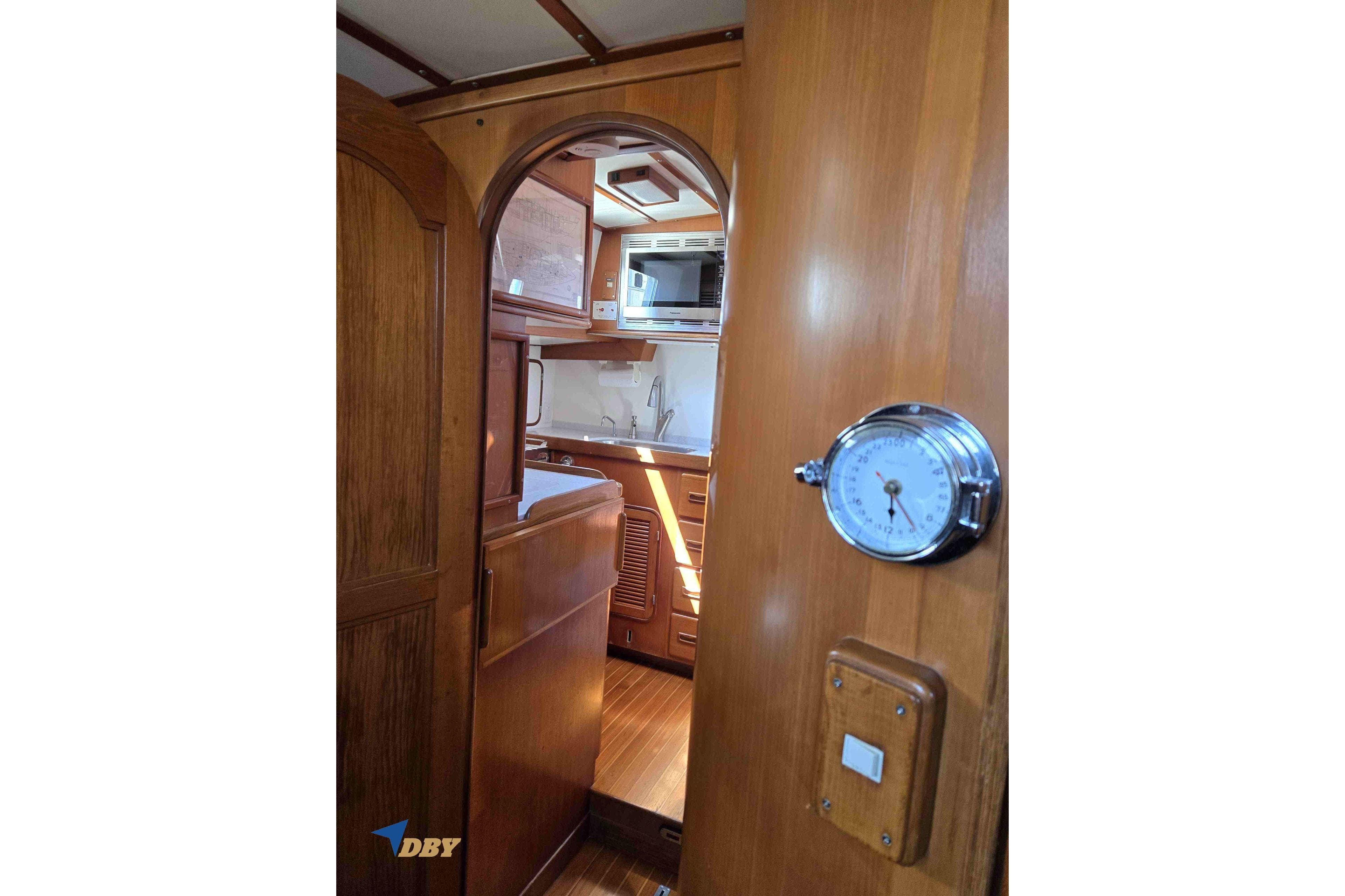 Interior of 1983 Mason 53 yacht, featuring wooden cabinetry and nautical decor.