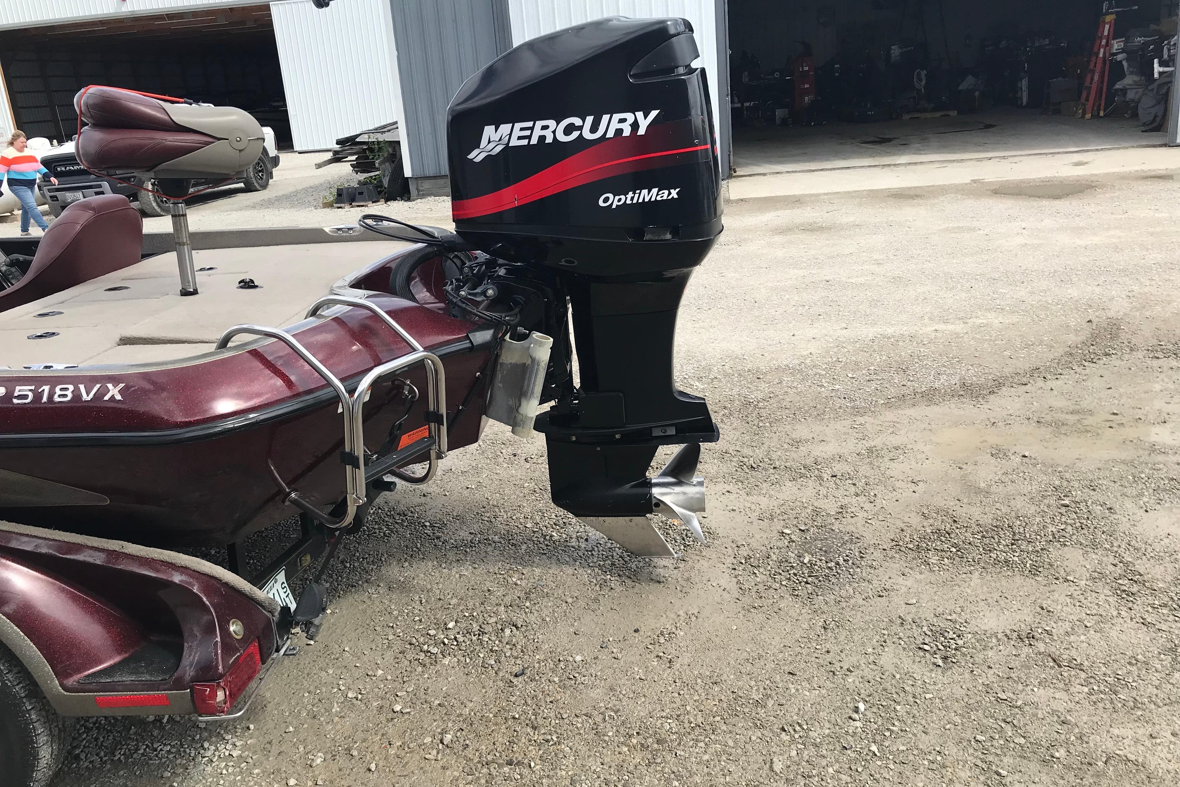 2001 Ranger 518DVX Comanche boat with Mercury OptiMax engine, parked outdoors.