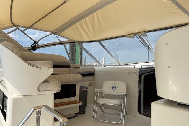 1988 Trojan 13 Meter Express 430 yacht interior with seating and helm under canopy.
