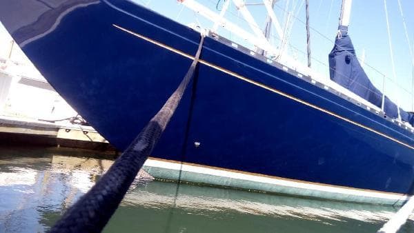 Blue 1993 Columbia Cutter sailboat docked in marina, side view.