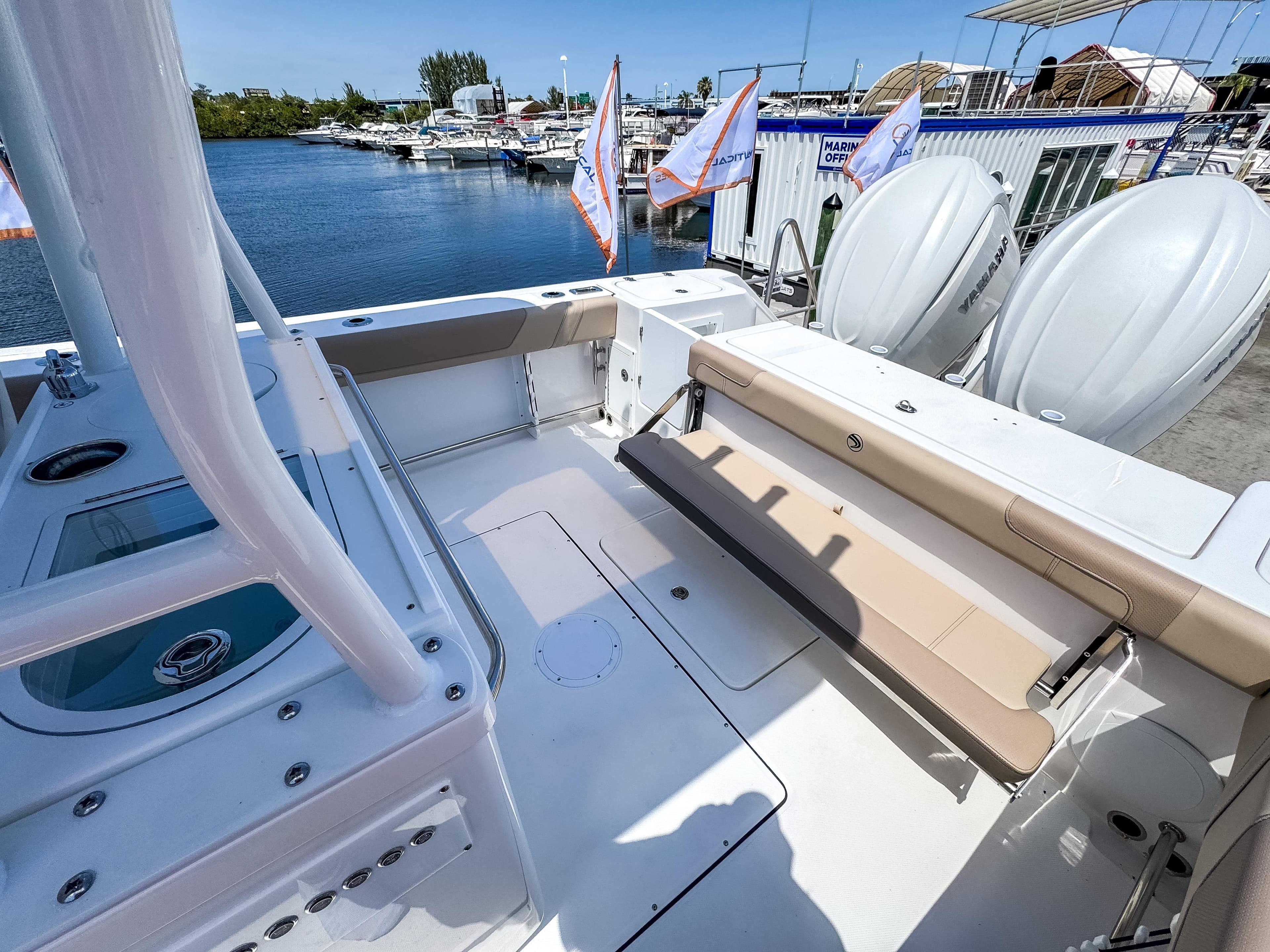 2025 Edgewater 325CC boat with spacious deck and seating, docked near water.