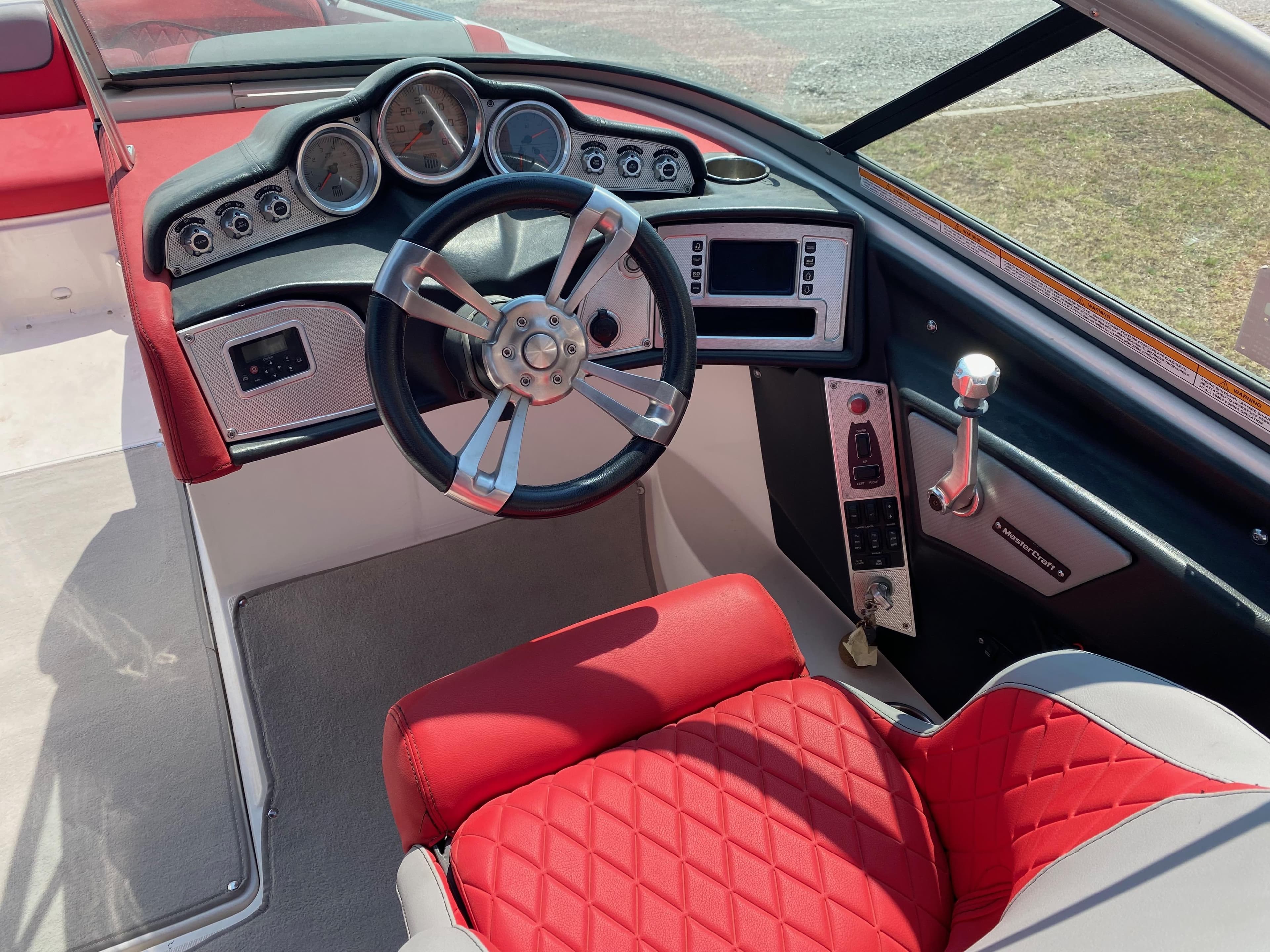 2013 MasterCraft X-35 boat interior with red seats and modern dashboard controls.
