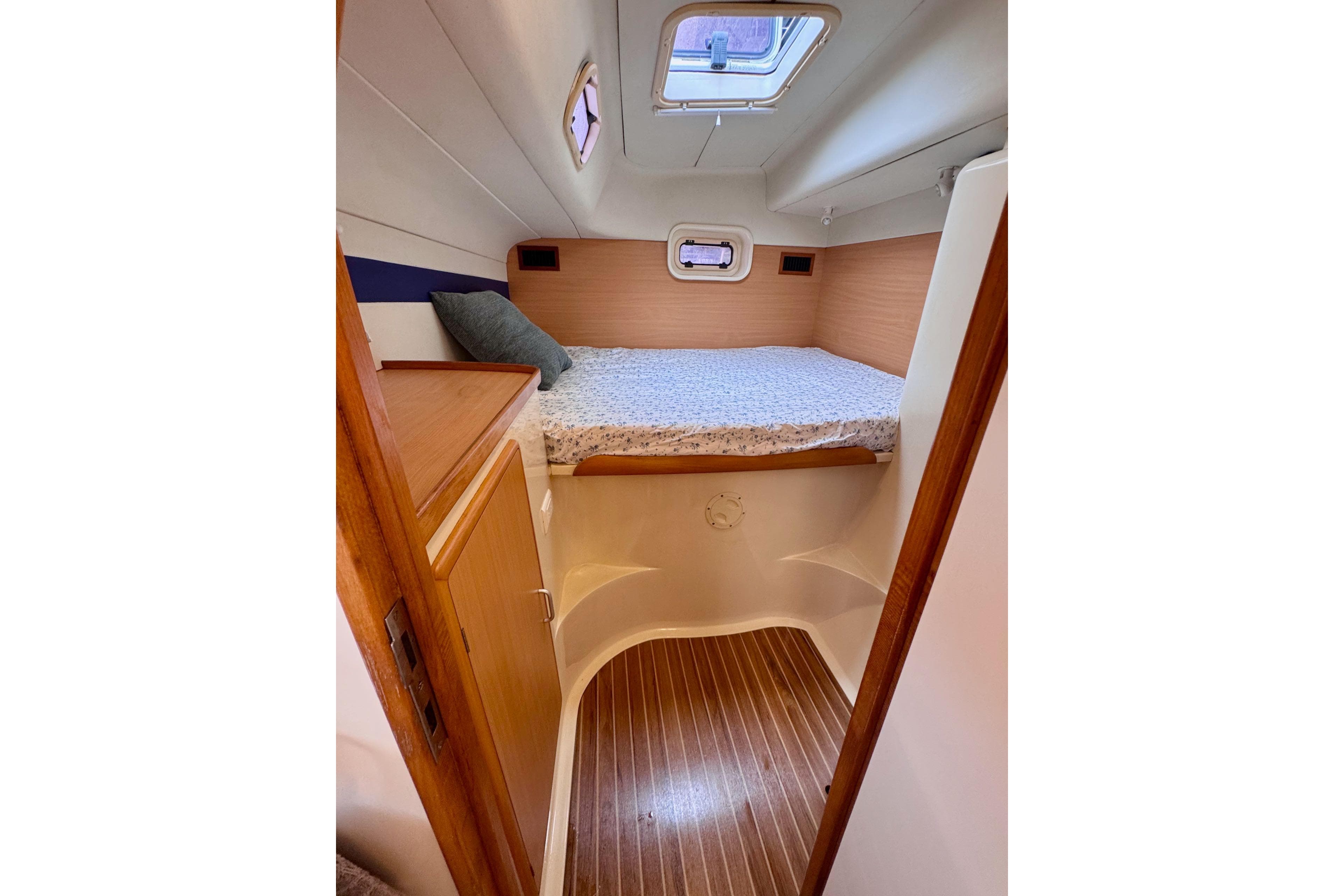 Cozy cabin interior of 2004 Leopard 42 yacht with bed and wooden accents.