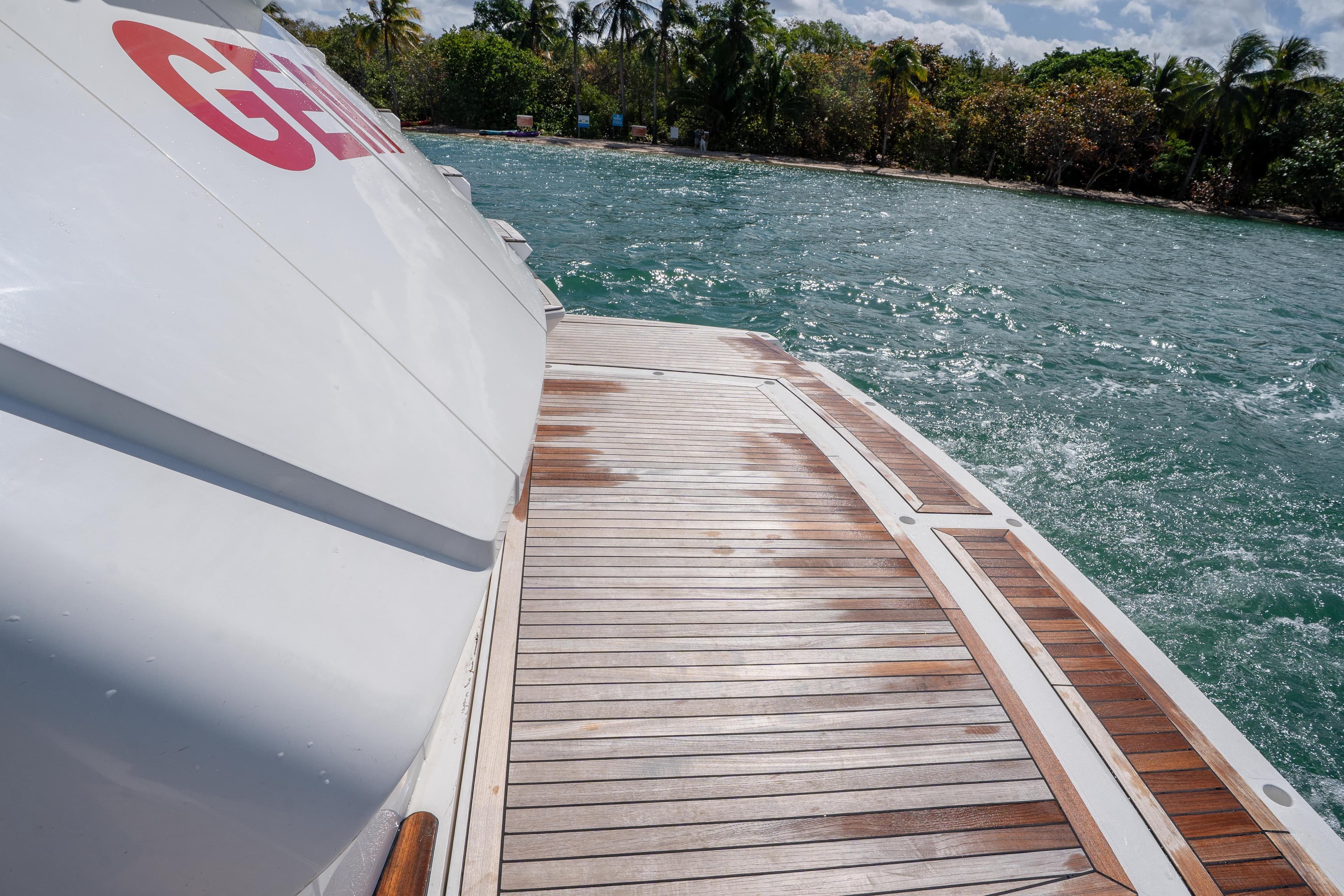 Sunseeker 68 Sport Yacht 2014, teak deck, ocean view, tropical backdrop, luxury boating experience.