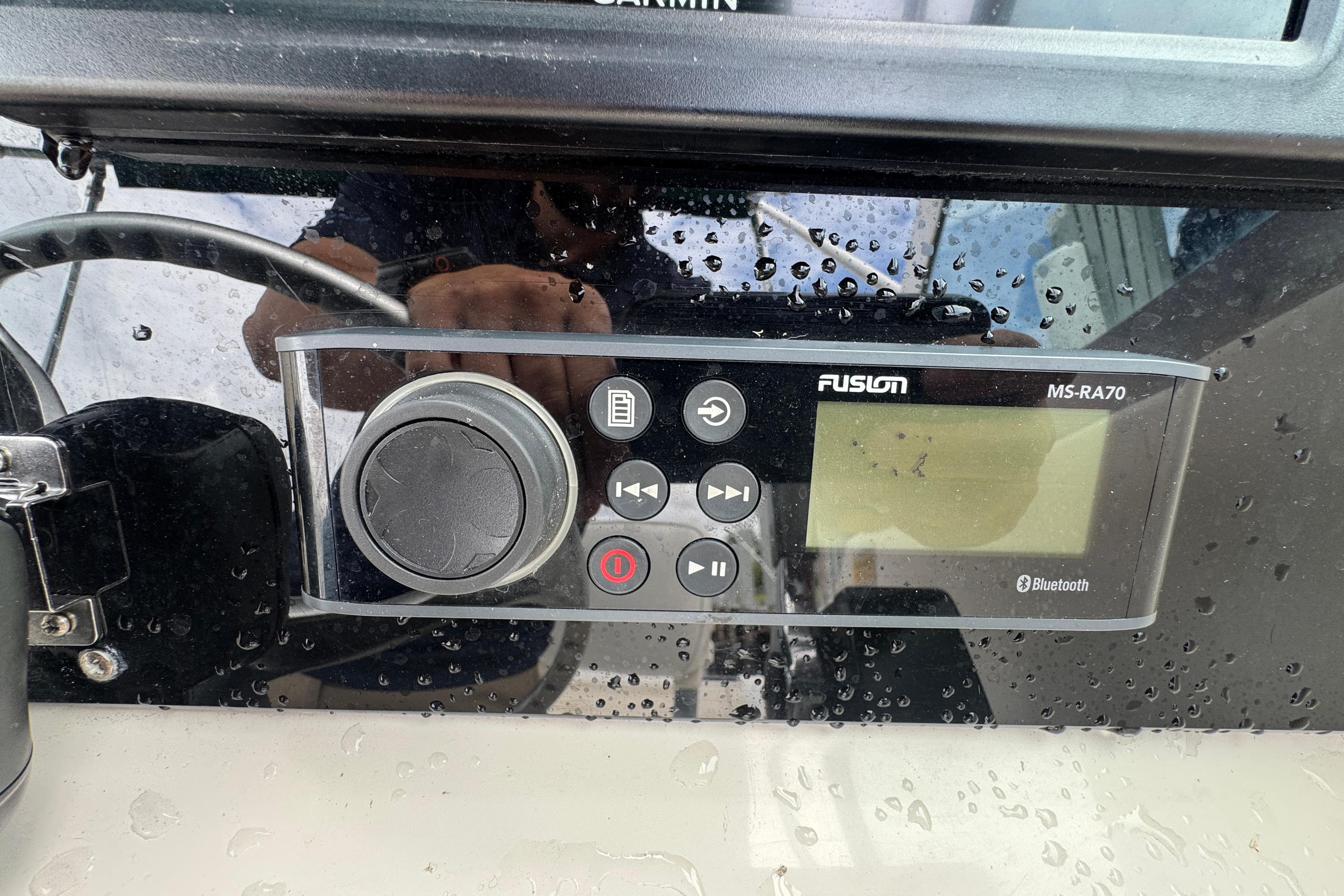 Fusion MS-RA70 marine stereo on a 2000 Pursuit 2470 Walkaround boat dashboard.