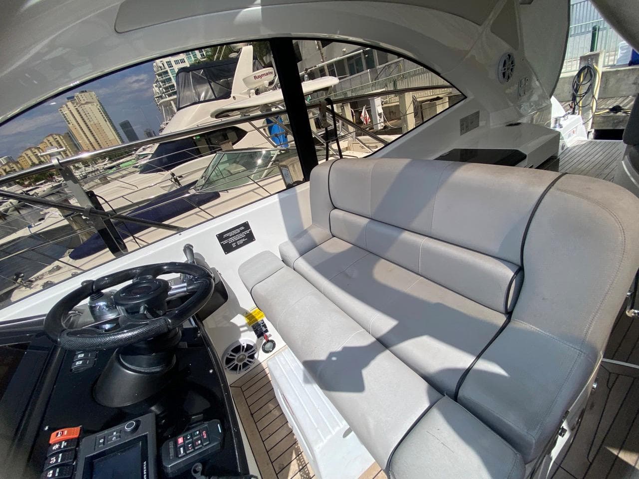 Interior of 2014 Sunseeker 48 Portofino XPS yacht with plush seating and steering wheel.