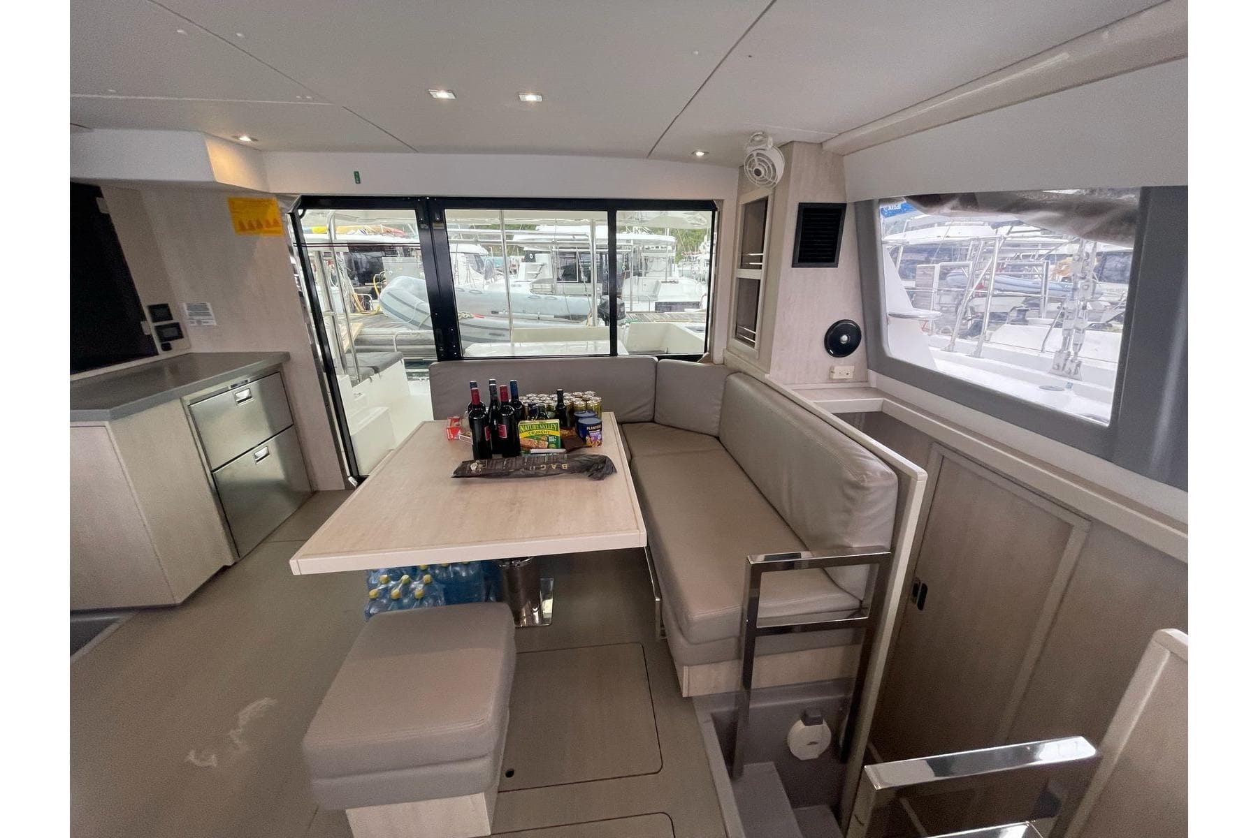 Modern interior of 2020 Leopard 40 catamaran with dining area and beverages on table.