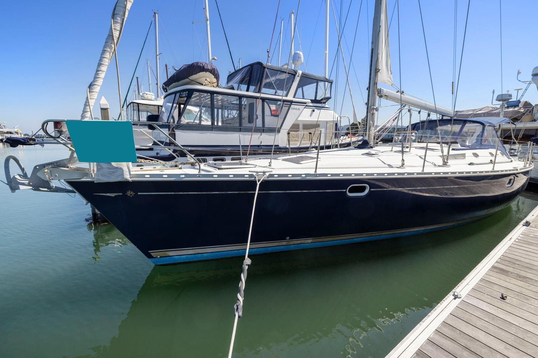 2001 Jeanneau Sun Odyssey 52.2 sailboat docked in marina, clear blue sky.