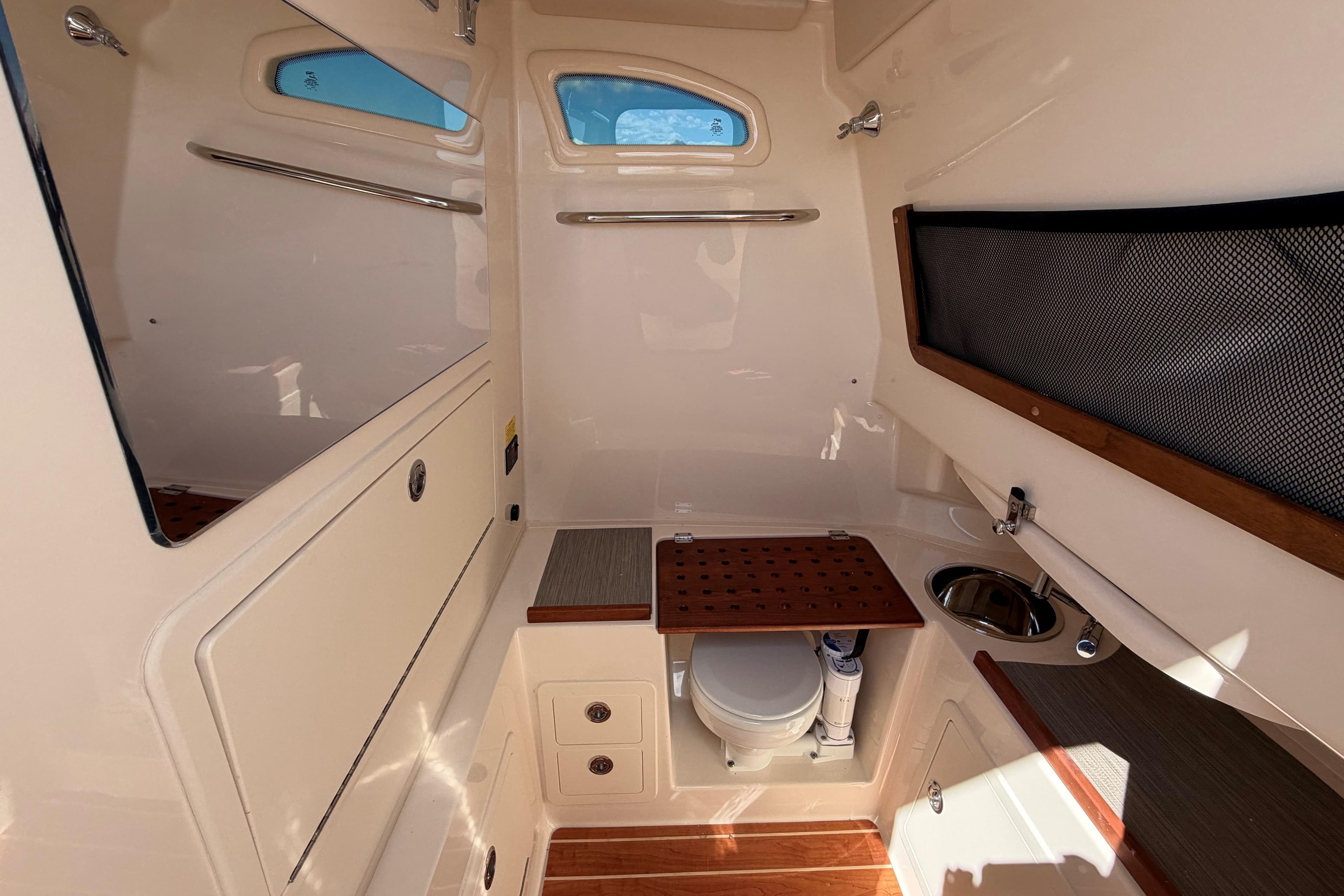Interior of 2026 Grady-White Canyon 306 boat, featuring a compact bathroom with sink and storage.