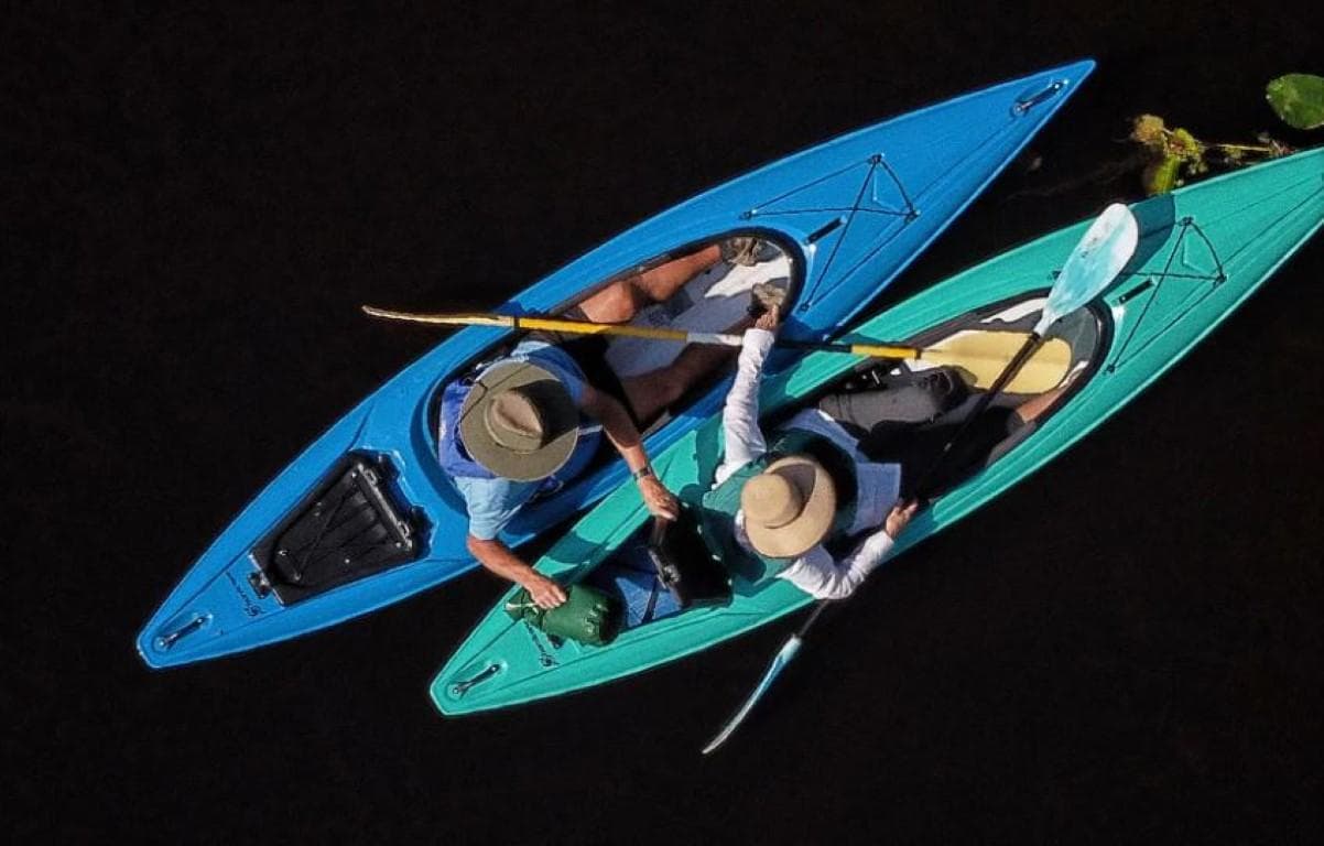 Two people kayaking in Hurricane Kayaks Prima 125 Sport, 2023 model, on a calm water surface.