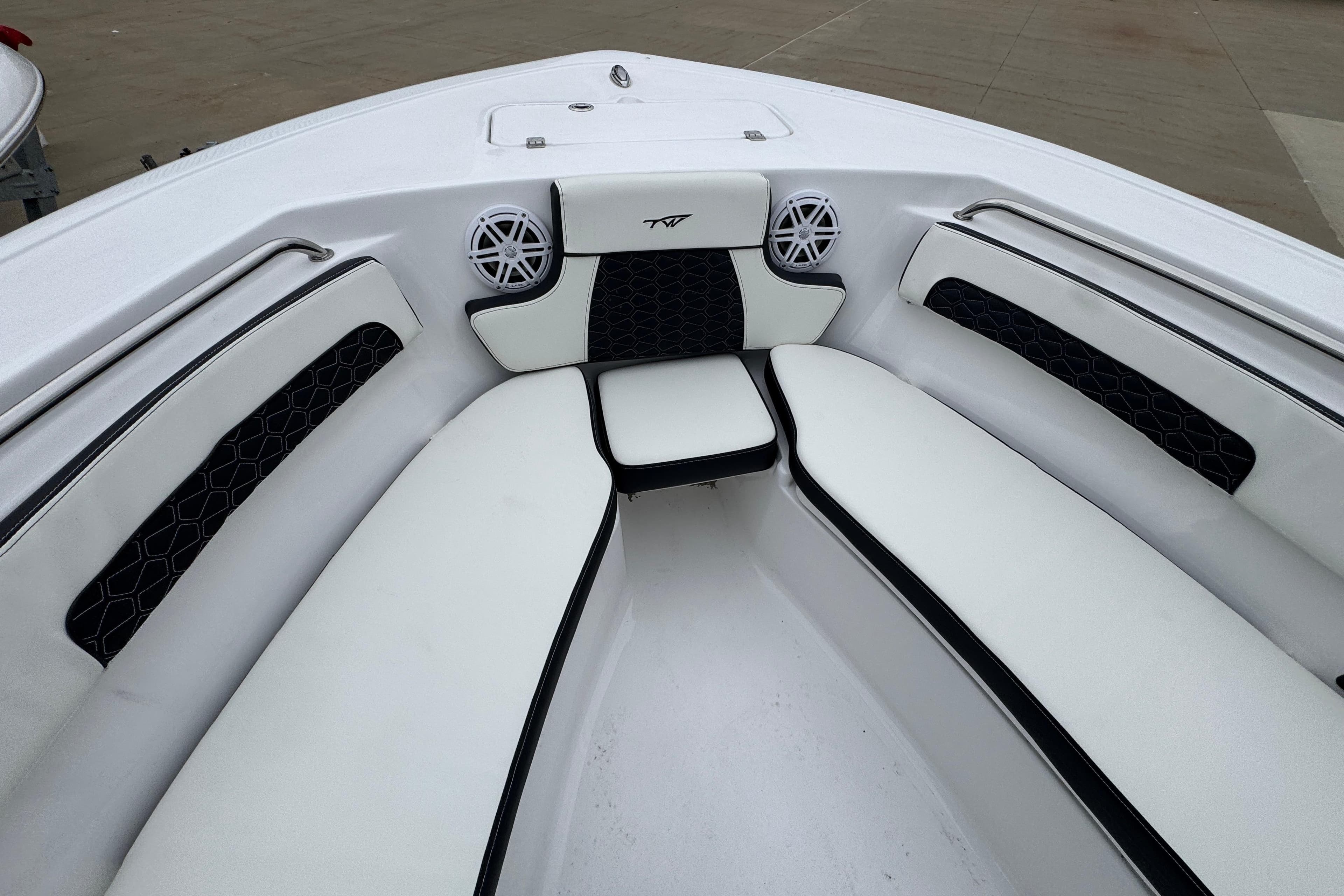 2026 Tidewater 220 LXF boat interior with white cushioned seating and speakers.