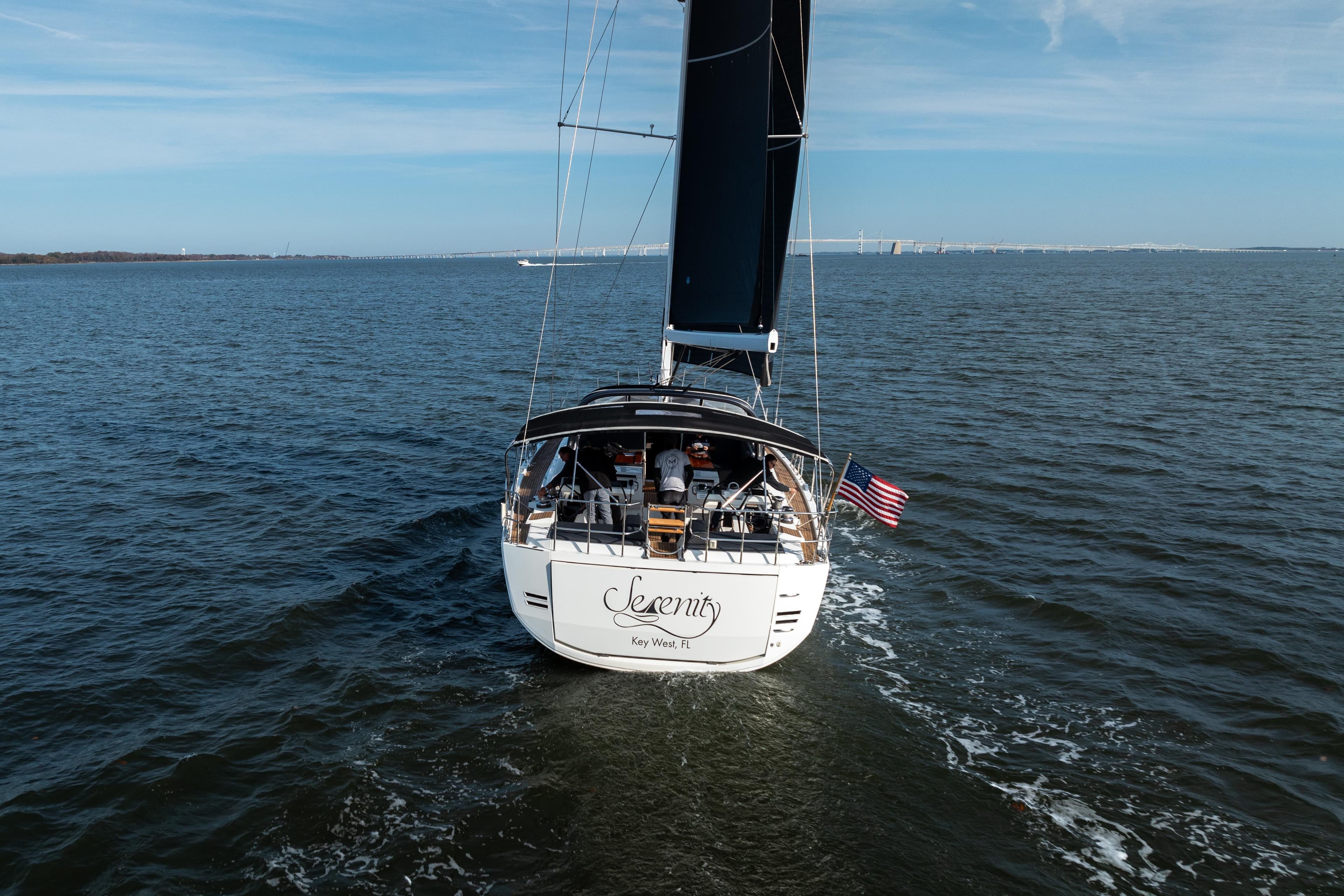 2016 Jeanneau 64 sailboat cruising on open water, rear view.