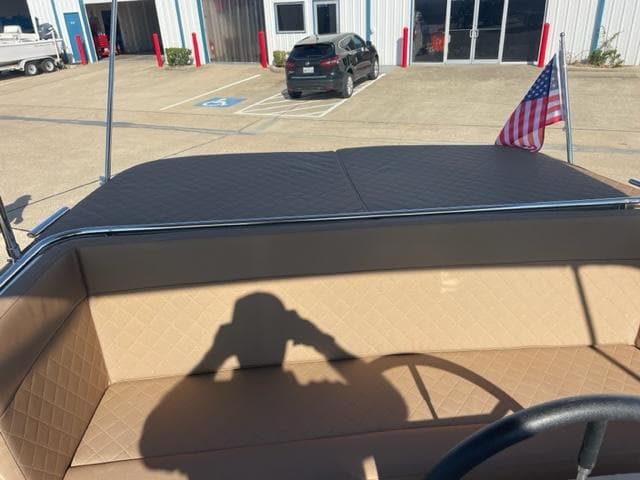 Maxima 620 Retro 2023 boat with tan interior and American flag in parking lot.