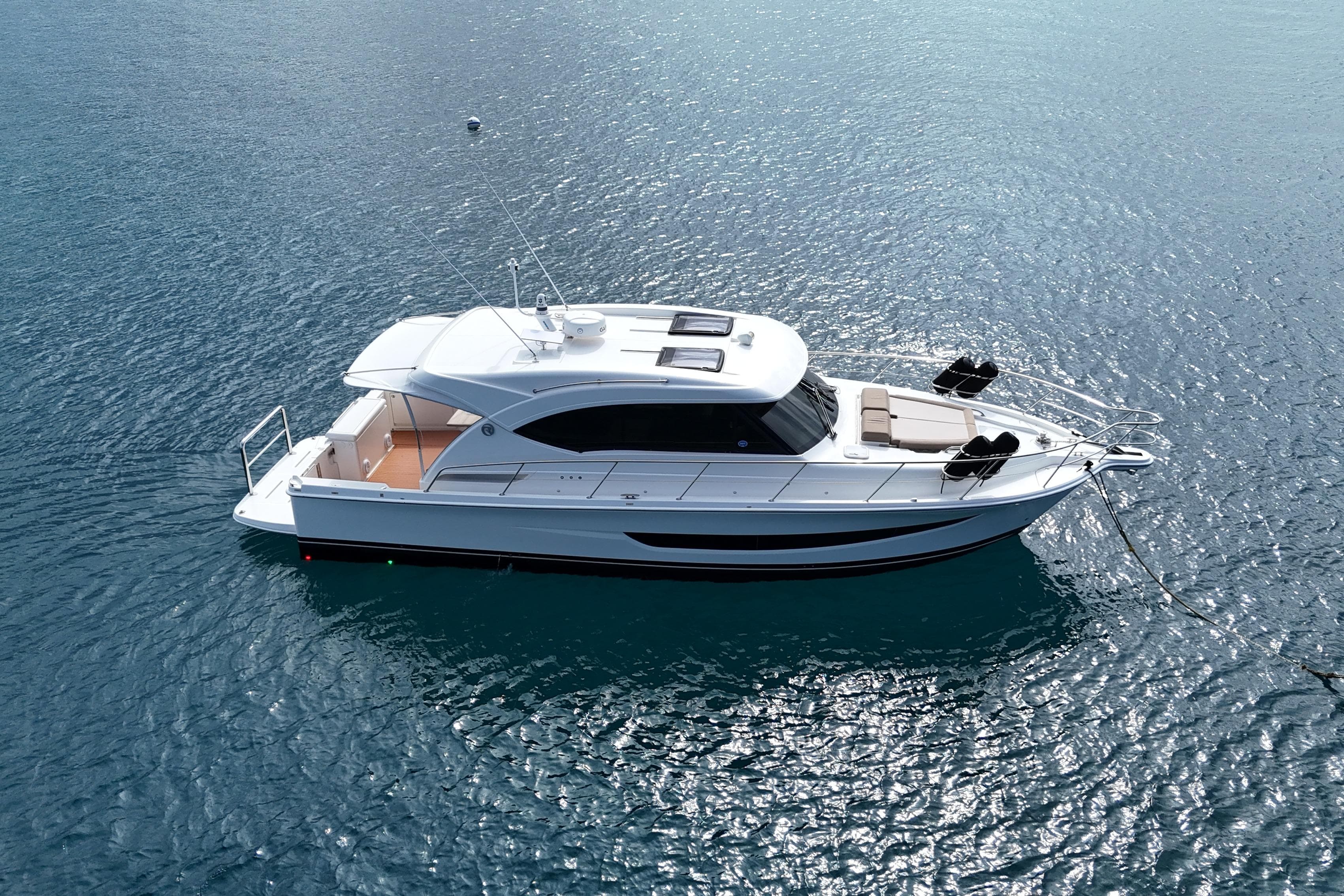 2020 Riviera 395 SUV yacht on calm blue water, aerial view.