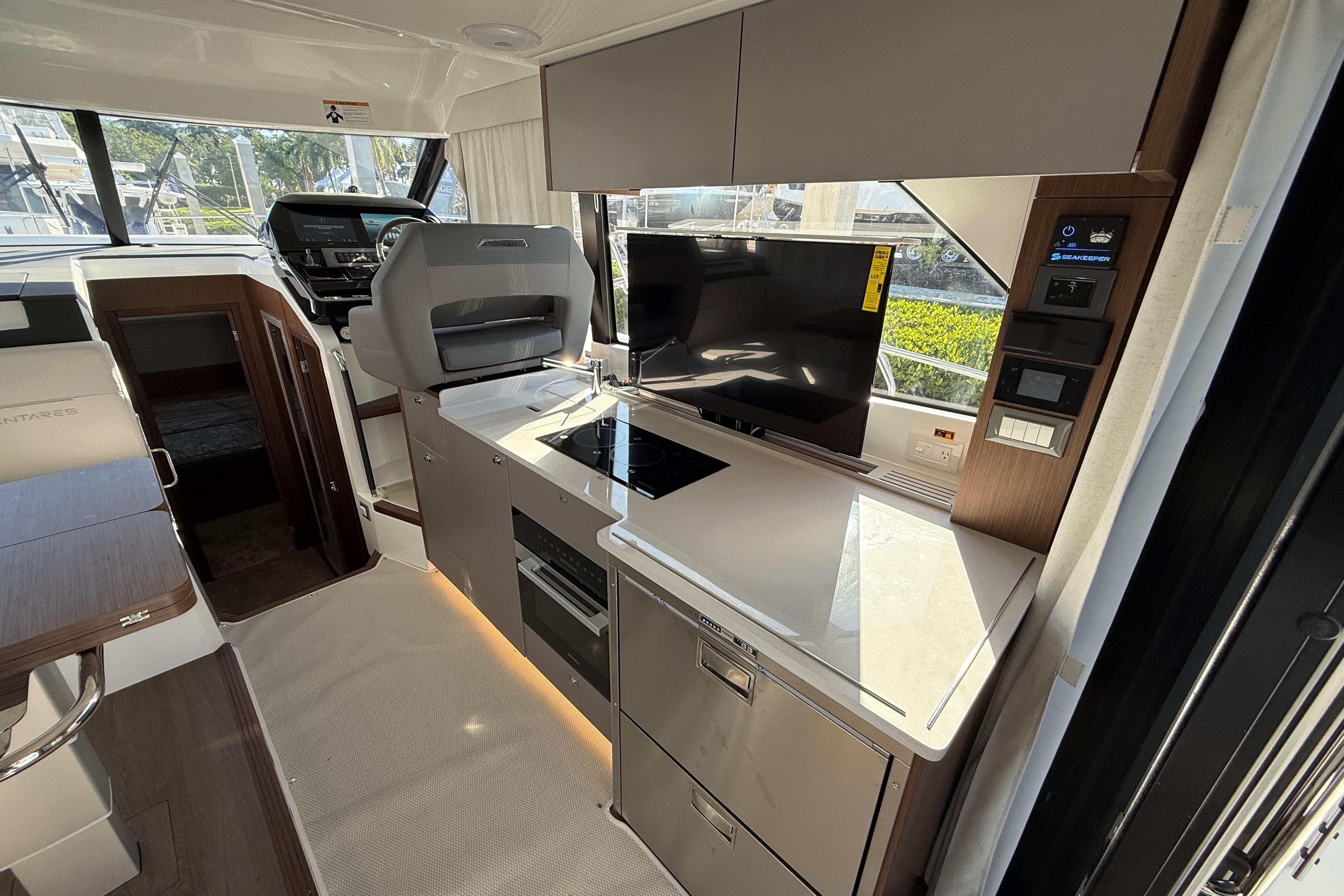 Modern interior of 2026 Beneteau Antares 12 yacht with sleek kitchen and navigation area.