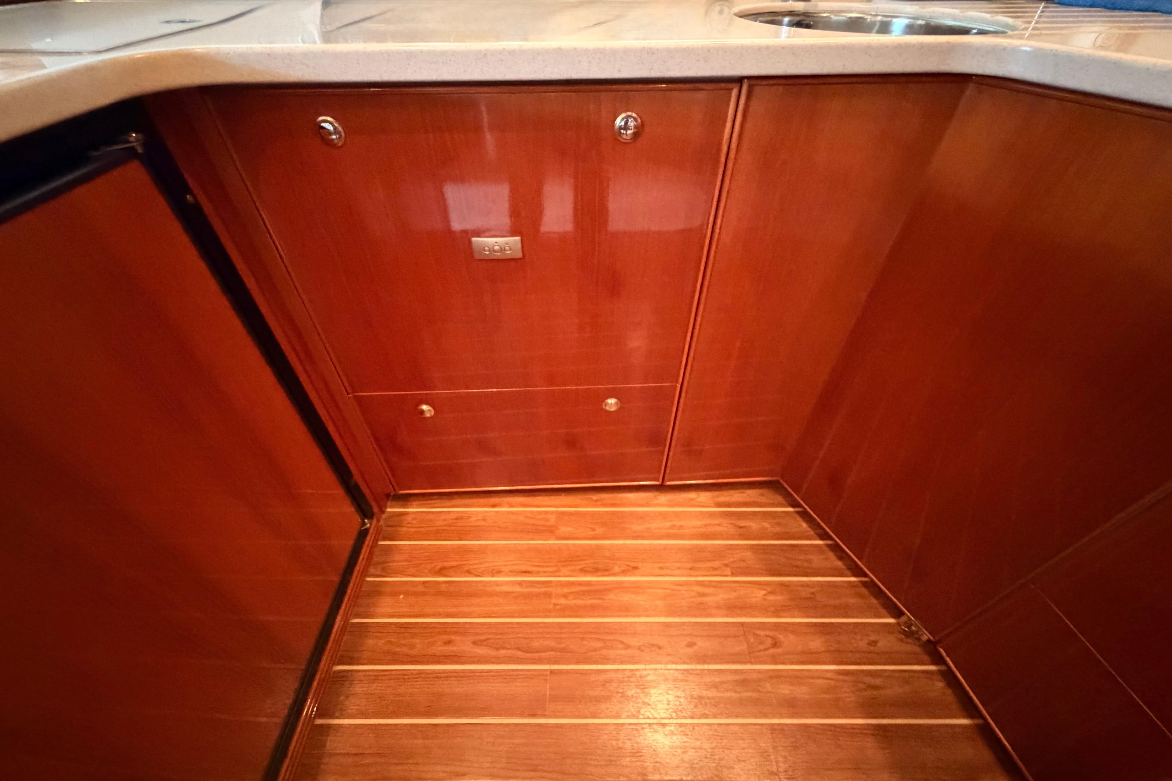Luxurious wooden cabinetry and flooring in 2004 Riviera 60 Flybridge yacht kitchen.